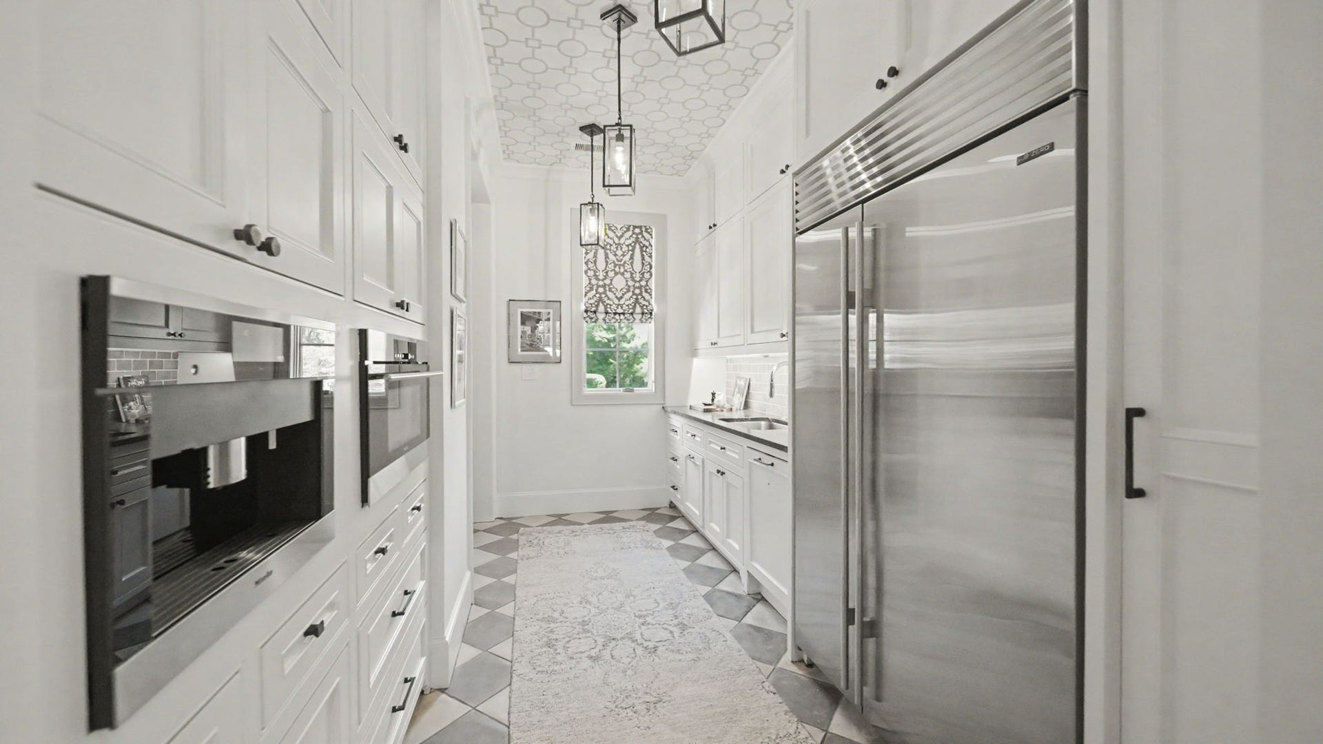 14 Peony Springs Court, The Woodlands, TX 77382 Catering Kitchen is fully equipped with a 48" Subzero, Wolf steamer, Miele coffee maker, sink, and dishwasher. The concrete checkered tiles on the floor and ceiling wallcovering add a uniqueness and flow nicely into the separate good neighbor door for easy access.