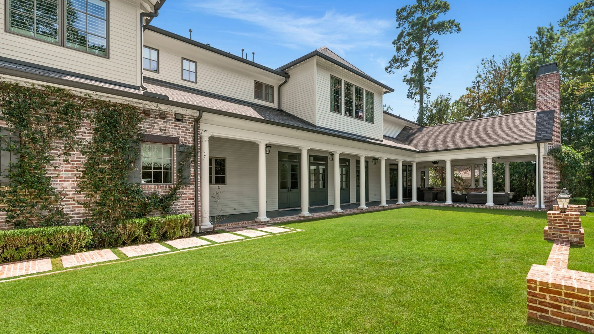 14 Peony Springs Court, The Woodlands, TX 77382 A columned veranda wraps the rear of the home, where a row of French doors opens onto the manicured lawn. 10' deep slate and brick patios deep enough for large gatherings sit under Bevolo gas Lanterns.