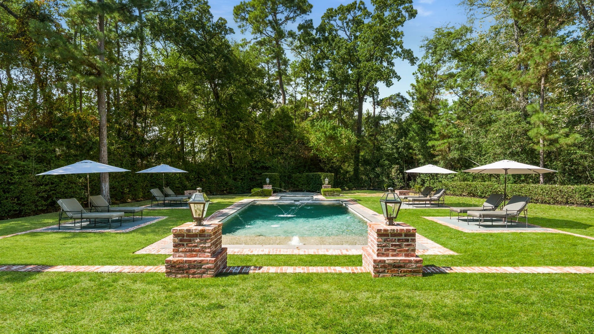 14 Peony Springs Court, The Woodlands, TX 77382 Four separate lounge pads surround the pool creating a spa-like escape framed by mature trees.