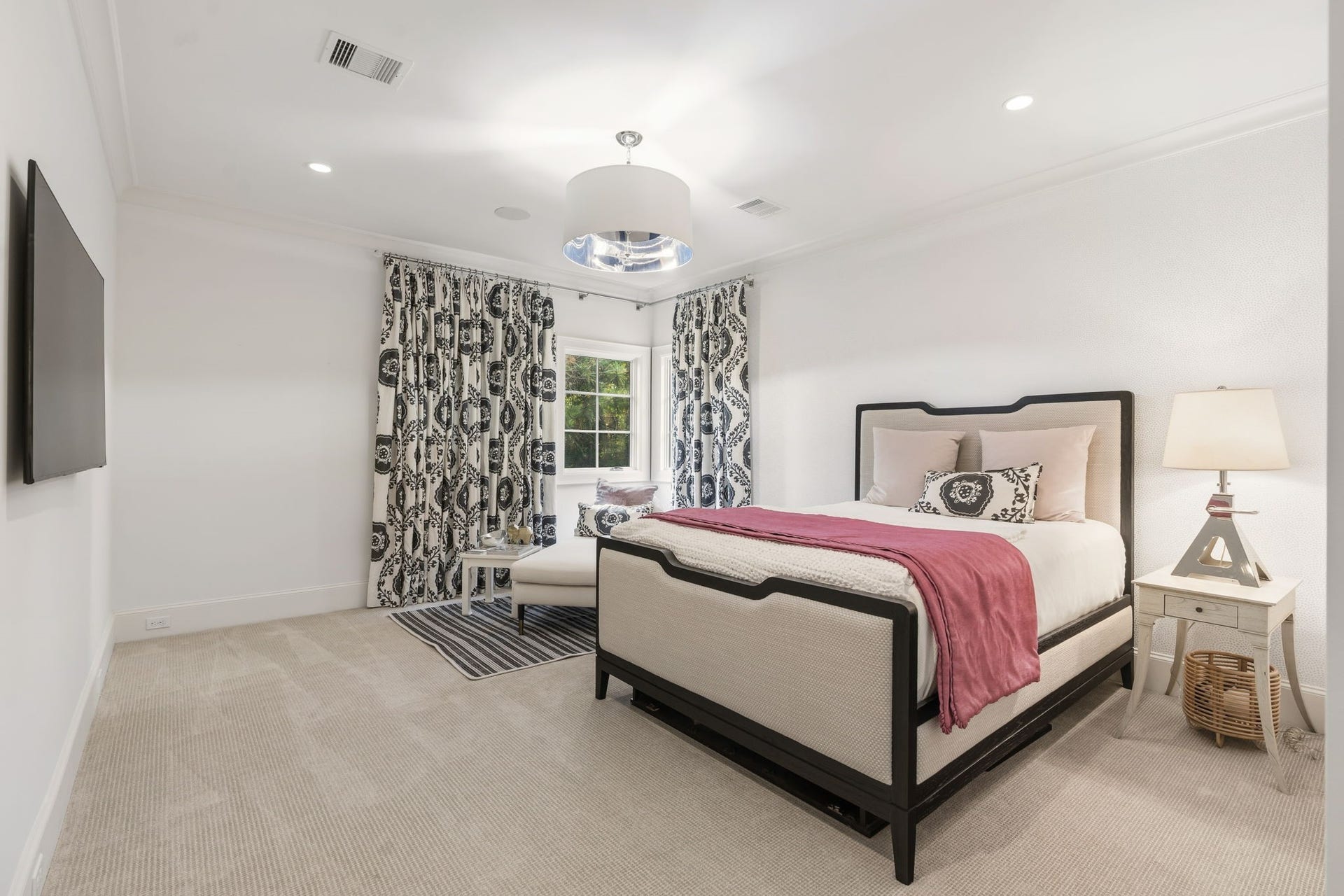 14 Peony Springs Court, The Woodlands, TX 77382 This second en suite bedroom offers a bright, airy layout with crown molding, plush carpet & a corner window nook ideal for a relaxed reading.