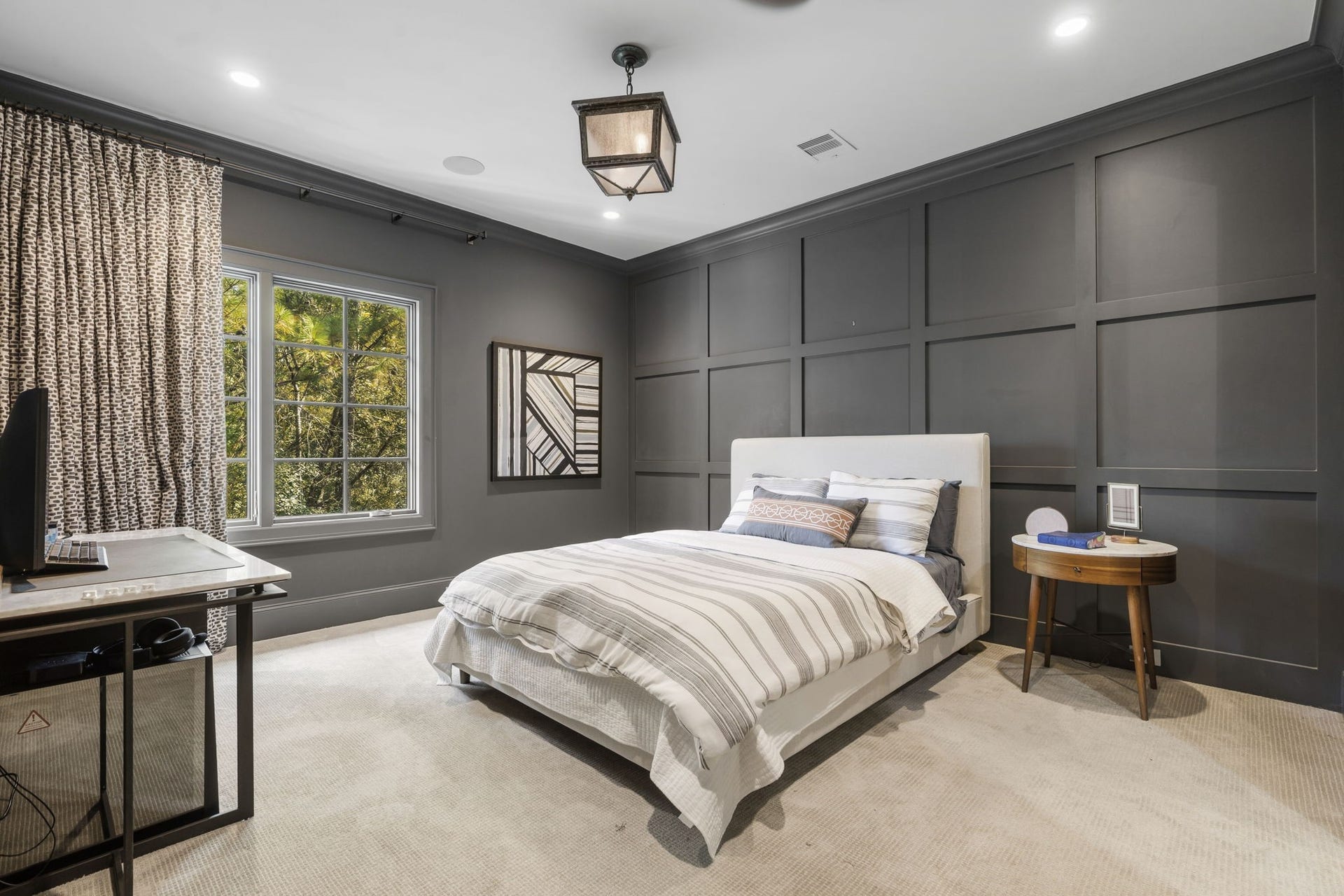 14 Peony Springs Court, The Woodlands, TX 77382 The first of three additional secondary en suite bedrooms features a paneled accent wall, crown molding & a large window framing treetop views.