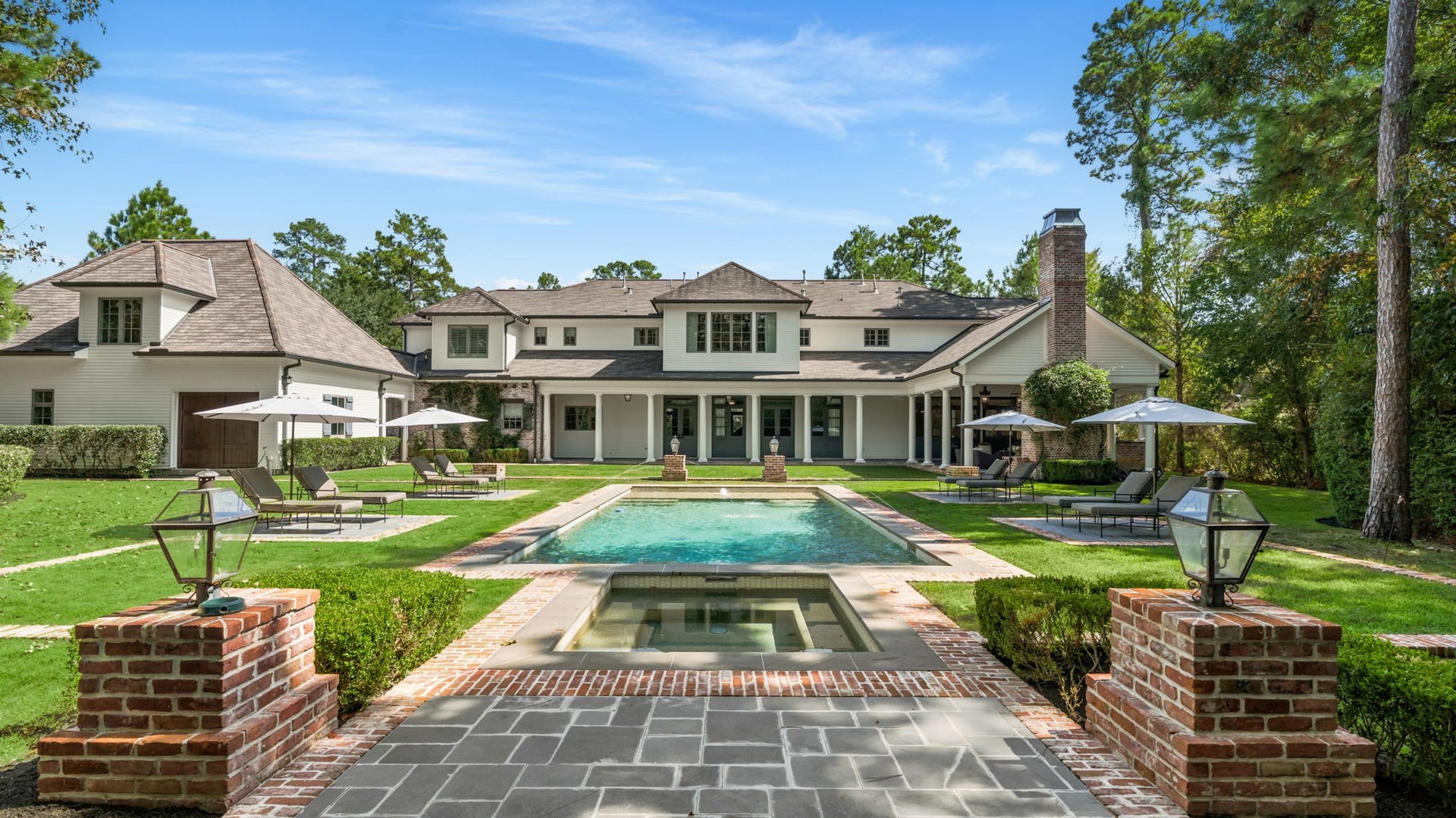 14 Peony Springs Court, The Woodlands, TX 77382 The backyard is an entertainer's dream, with a sparkling pool, hot tub & expansive lounge areas framed by brick pillars & gas lanterns.