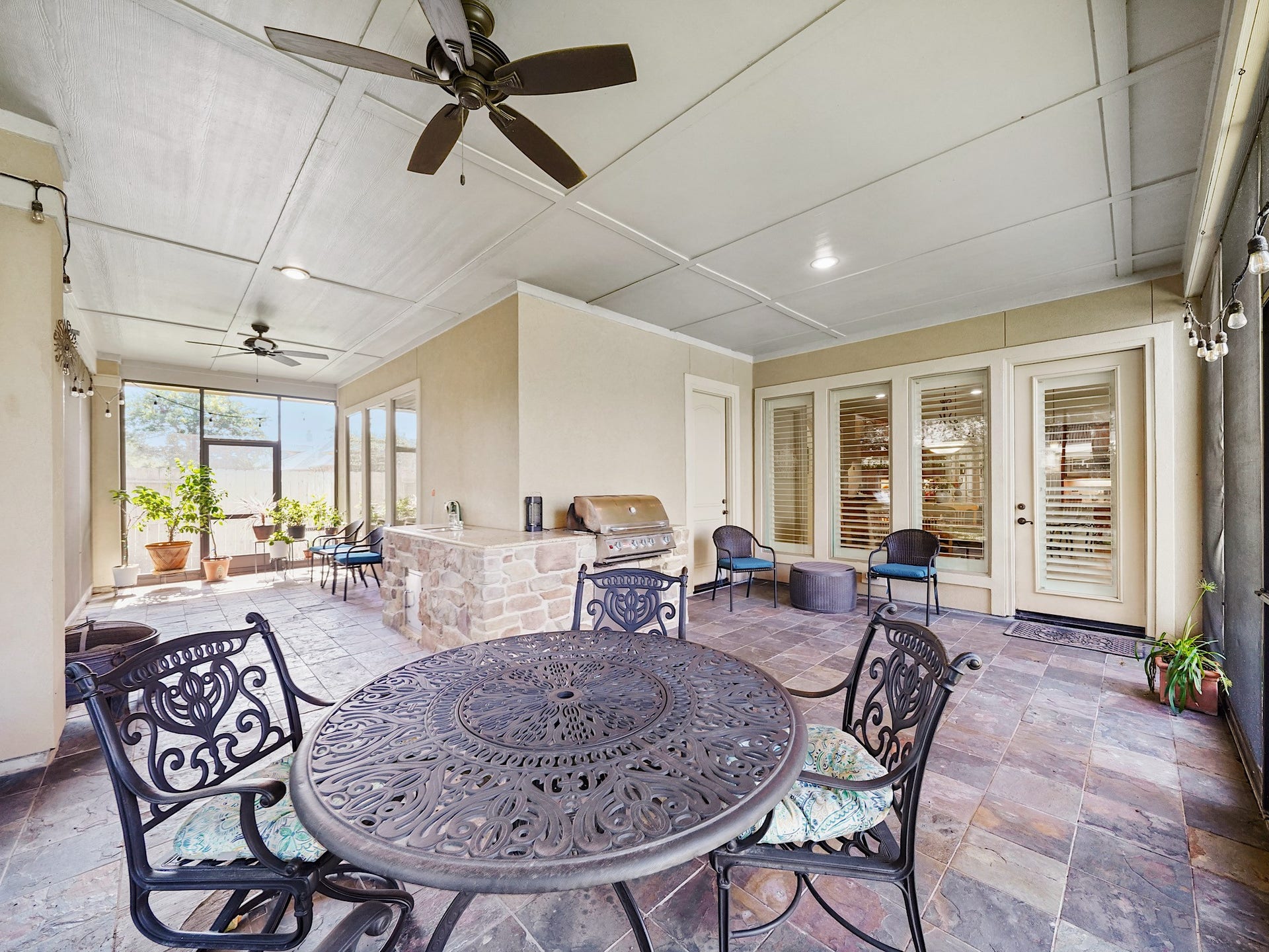 5907 Hawthorne Garden Way, Katy, TX 77494 The screened porch opens with a generous dining area, setting the scene for relaxed meals and unhurried weekend gatherings.