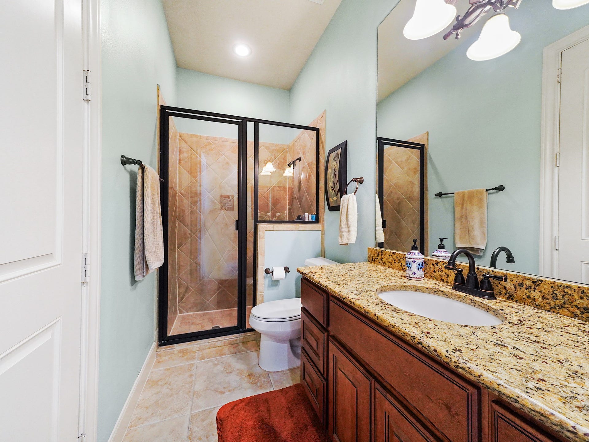 5907 Hawthorne Garden Way, Katy, TX 77494 Granite countertops, warm wood cabinetry, and crisp tile continue the homes elevated finish level in this full bath.