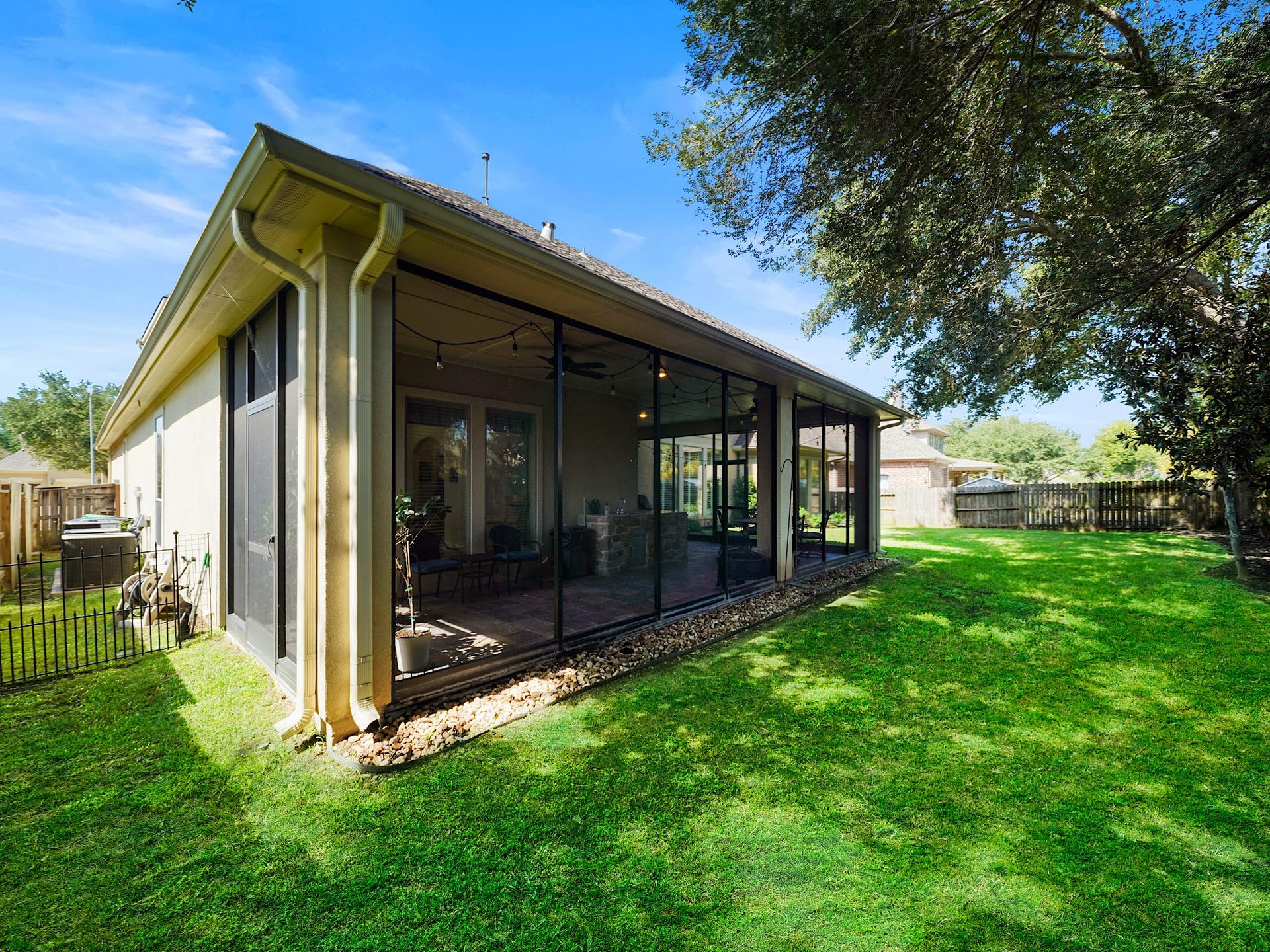 5907 Hawthorne Garden Way, Katy, TX 77494 From the backyard, the screened porch becomes a striking extension of the home, connecting indoor comfort with open-air living.