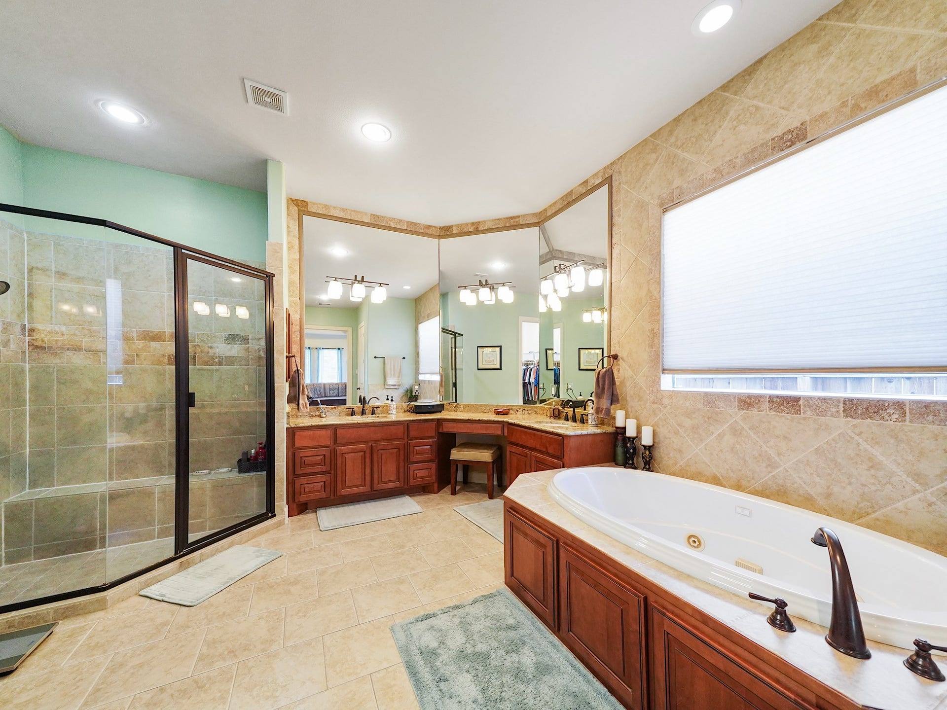 5907 Hawthorne Garden Way, Katy, TX 77494 The primary bath is designed for a slower pace, offering granite-topped vanities, abundant cabinetry, and a large jetted tub.