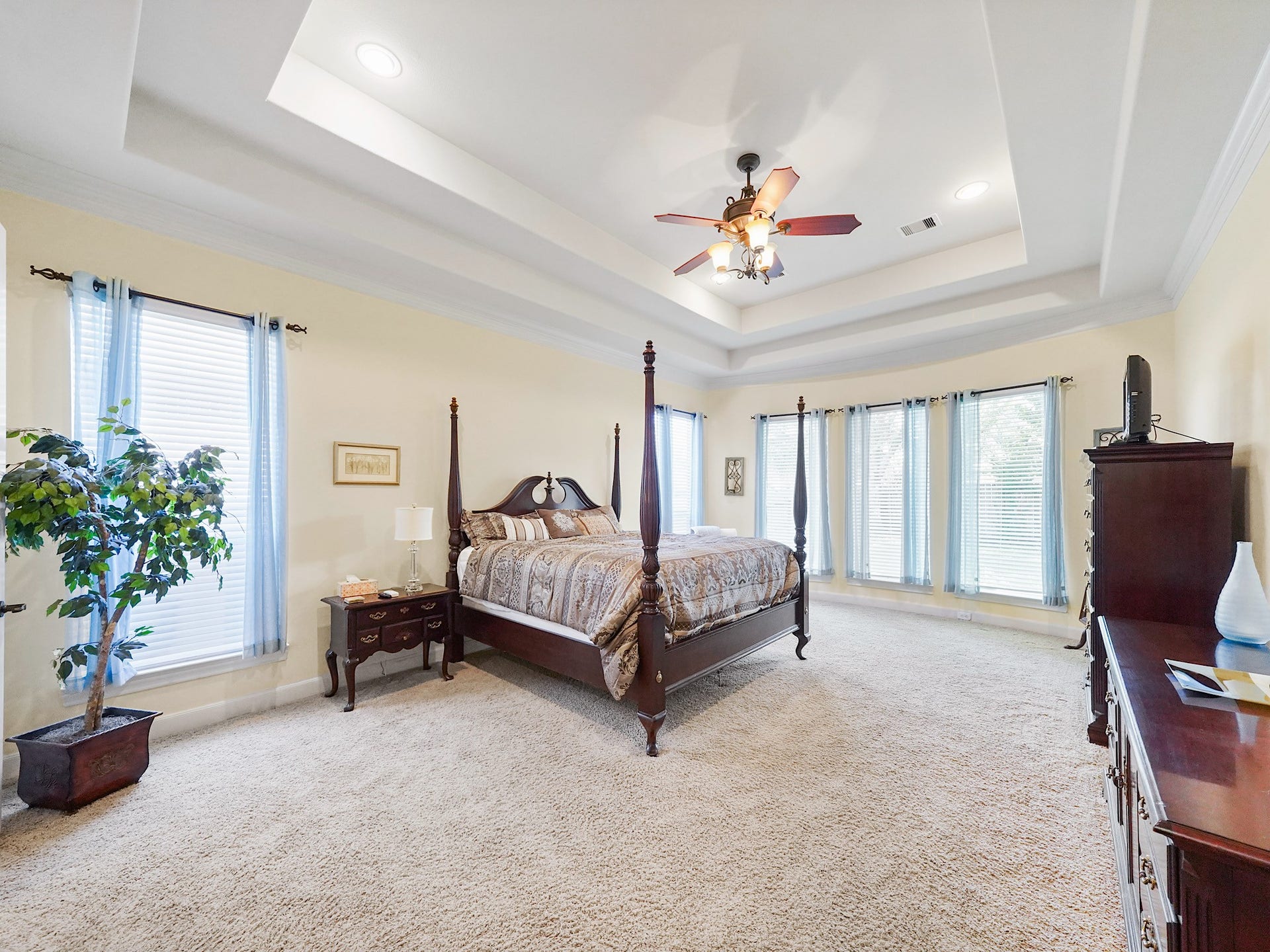 5907 Hawthorne Garden Way, Katy, TX 77494 The downstairs primary suite feels like a true retreat, with a tray ceiling, crown molding, and generous dimensions that allow room to unwind.