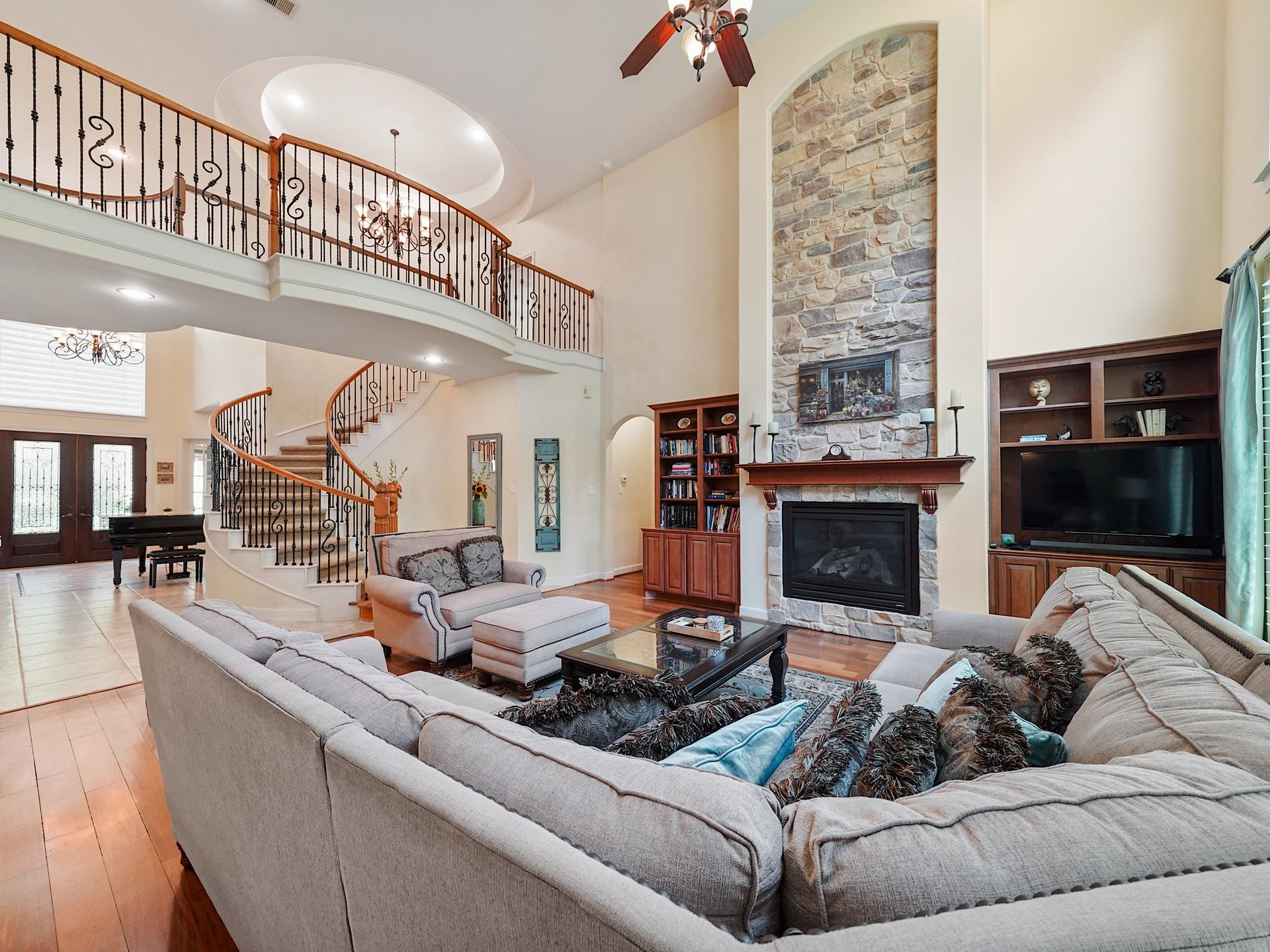 5907 Hawthorne Garden Way, Katy, TX 77494 The two-story family room feels both grand and inviting, where rich hardwood floors, a gas fireplace, and tall windows create a luminous setting for relaxed evenings and memorable gatherings.