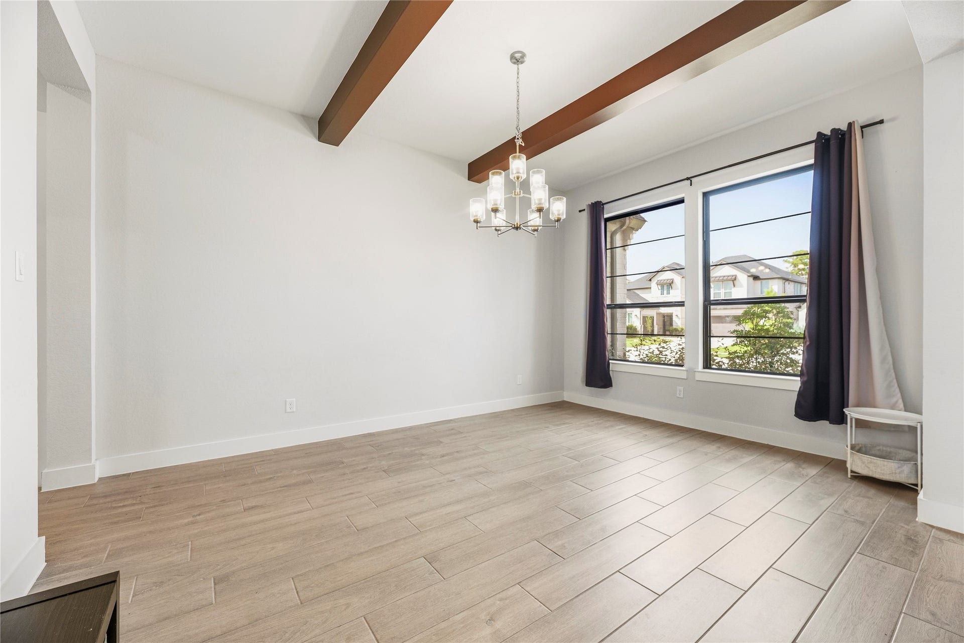 4810 Antler Run Drive, Spring, TX 77386 Bright and inviting dining area with wood-like tile flooring, elegant ceiling beams, and a stylish chandelier. Large windows bring in natural light and offer pleasant neighborhood views. The exposed beams are an upgrade!