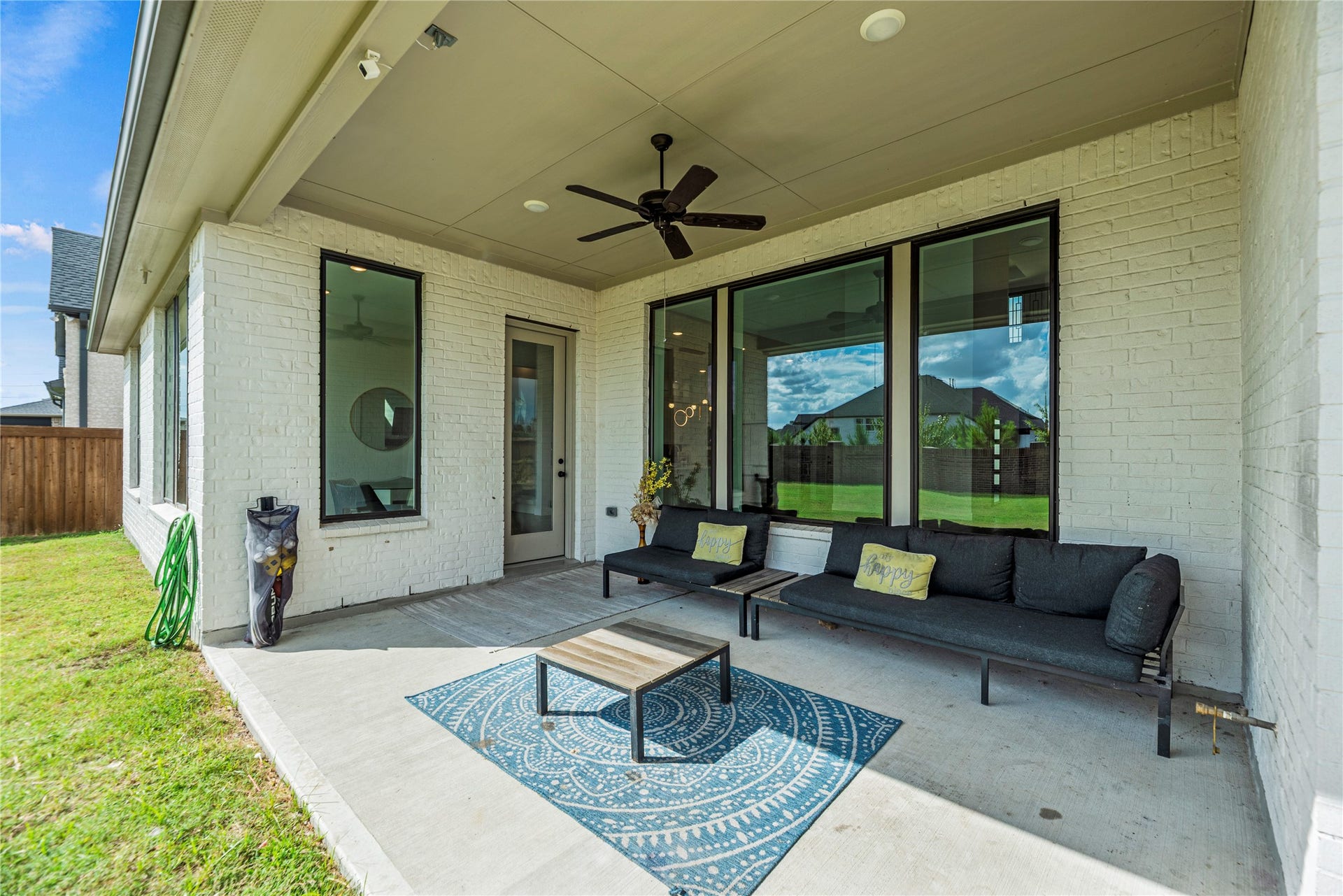 4810 Antler Run Drive, Spring, TX 77386 Charming covered patio with cozy seating, a ceiling fan, and ample space for outdoor relaxation, overlooking a lush backyard.