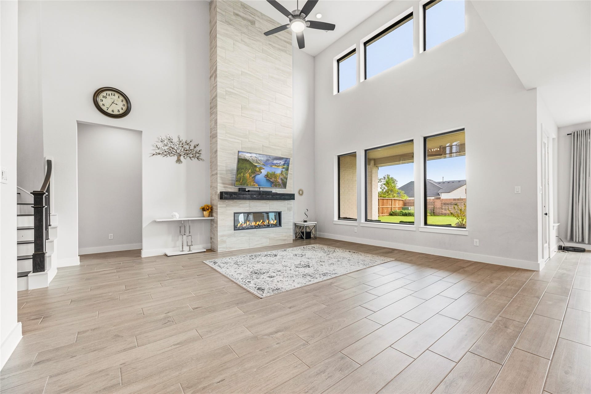 4810 Antler Run Drive, Spring, TX 77386 Spacious living room with high ceilings, abundant natural light from large windows, and a modern fireplace, perfect for relaxation and entertaining.