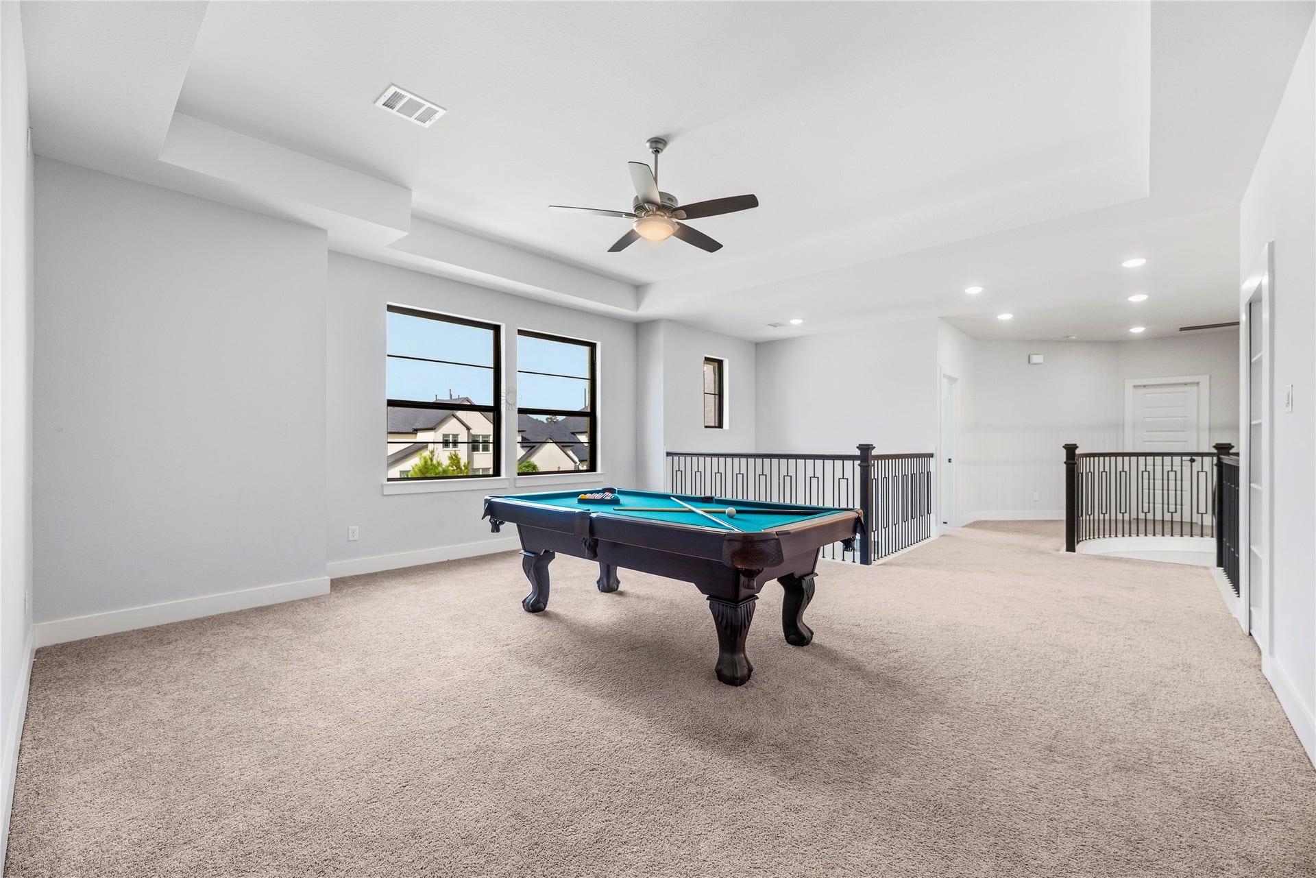 4810 Antler Run Drive, Spring, TX 77386 Spacious game room with a pool table, plush carpeting, and large windows offering ample natural light, perfect for entertainment and relaxation.