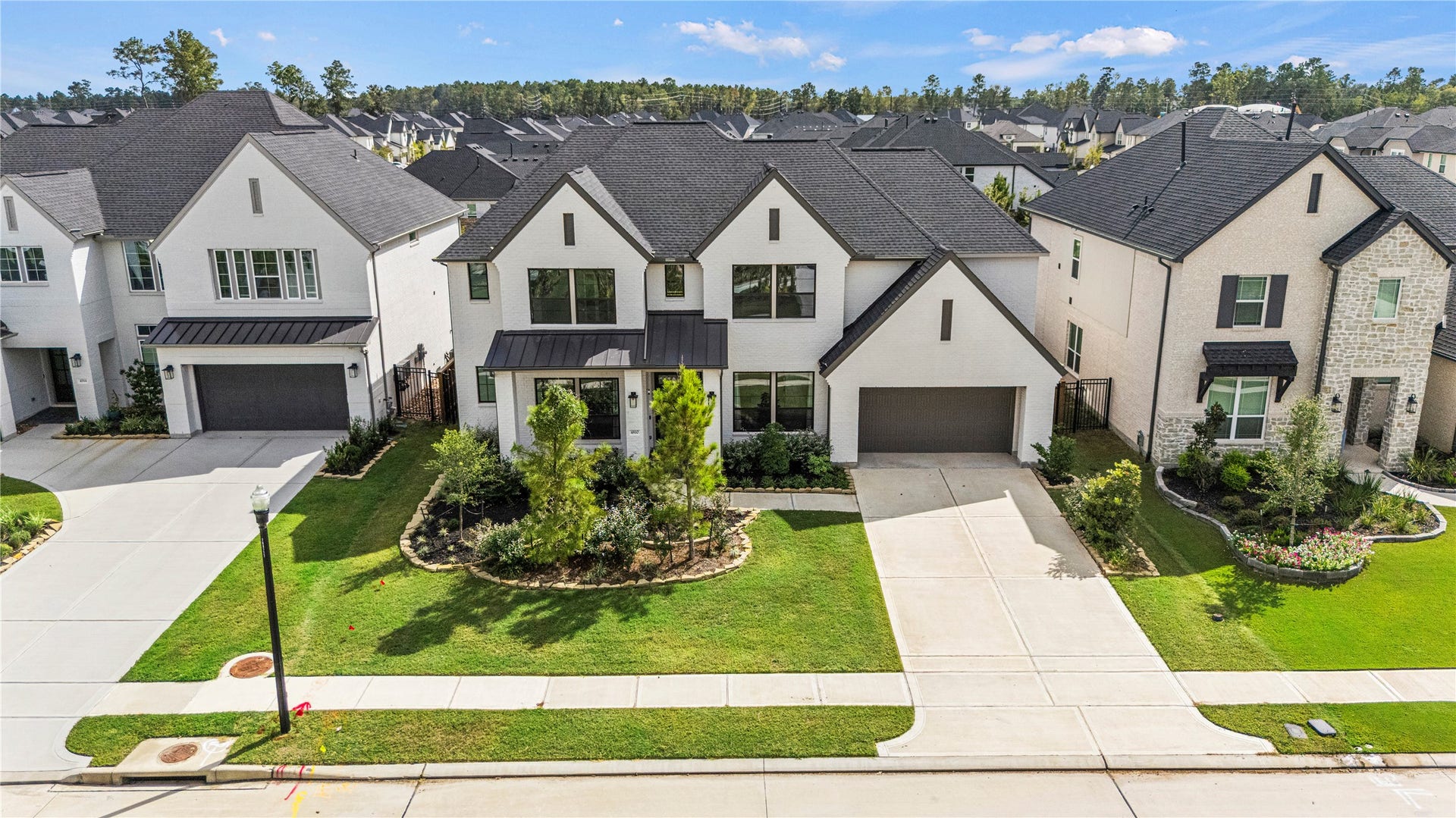 4810 Antler Run Drive, Spring, TX 77386 Stunning two-story home with a modern facade and black accents, complete with a spacious three-car garage and beautifully landscaped front yard.