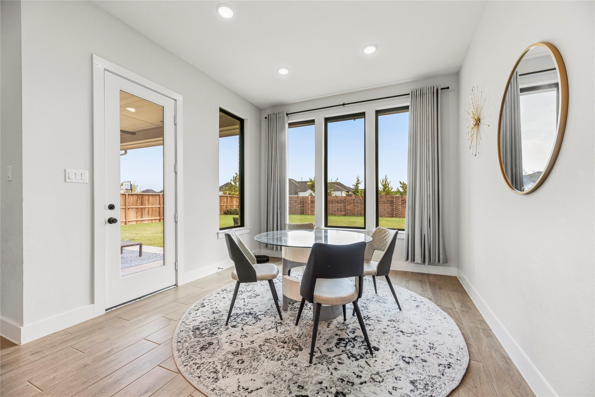 4810 Antler Run Drive, Spring, TX 77386 Dining area with large windows and patio access, featuring modern decor and a round glass table perfect for intimate gatherings. Did someone order some natural light?!