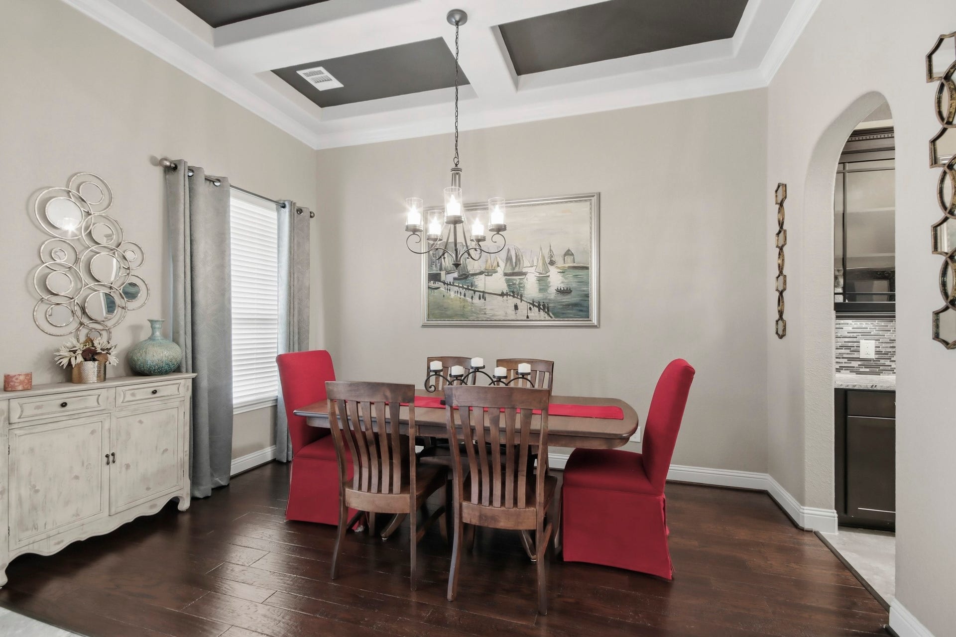 11 Whispering Thicket Place, The Woodlands, TX 77375 Elegant dining room featuring a coffered ceiling, stylish chandelier, and rich hardwood floors.