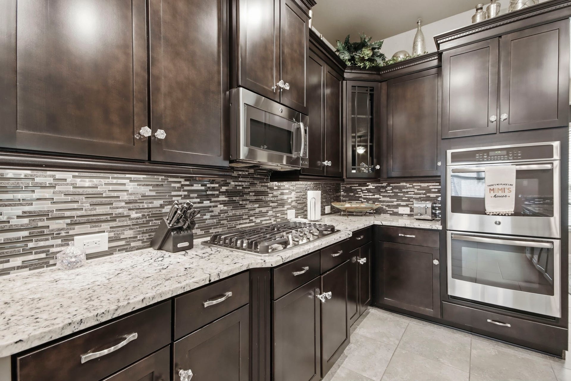 11 Whispering Thicket Place, The Woodlands, TX 77375 Stylish mosaic tile backsplash, dual stainless ovens and cooktop.