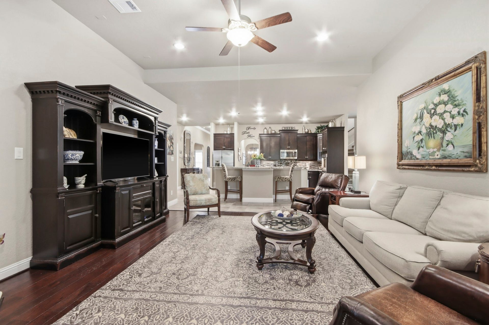11 Whispering Thicket Place, The Woodlands, TX 77375 Spacious open-concept living area with cozy seating and a stylish kitchen with a breakfast bar, perfect for everyday living and entertaining.