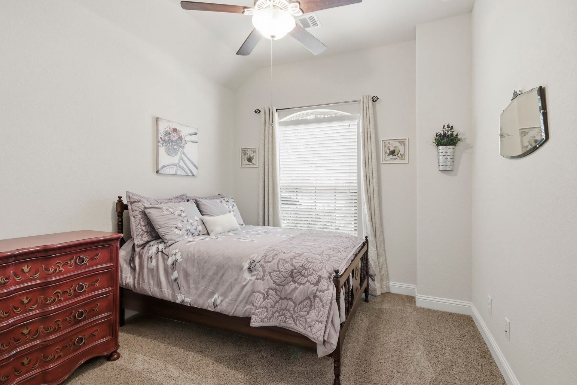 11 Whispering Thicket Place, The Woodlands, TX 77375 Front secondary bedroom with soft neutral tones, complemented by a window with natural light and stylish drapes.