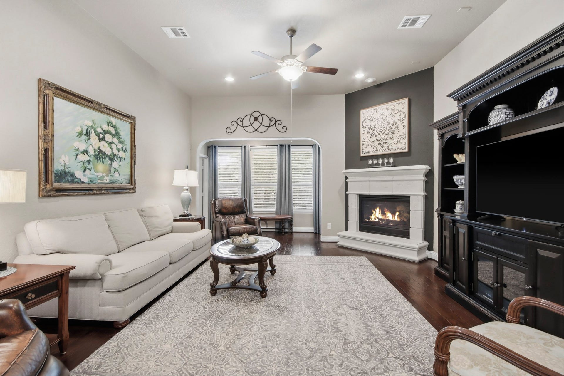 11 Whispering Thicket Place, The Woodlands, TX 77375 Inviting family room featuring a cozy fireplace, custom built-in shelving, and a stylish neutral palette. Perfect for relaxing or entertaining family and friends.