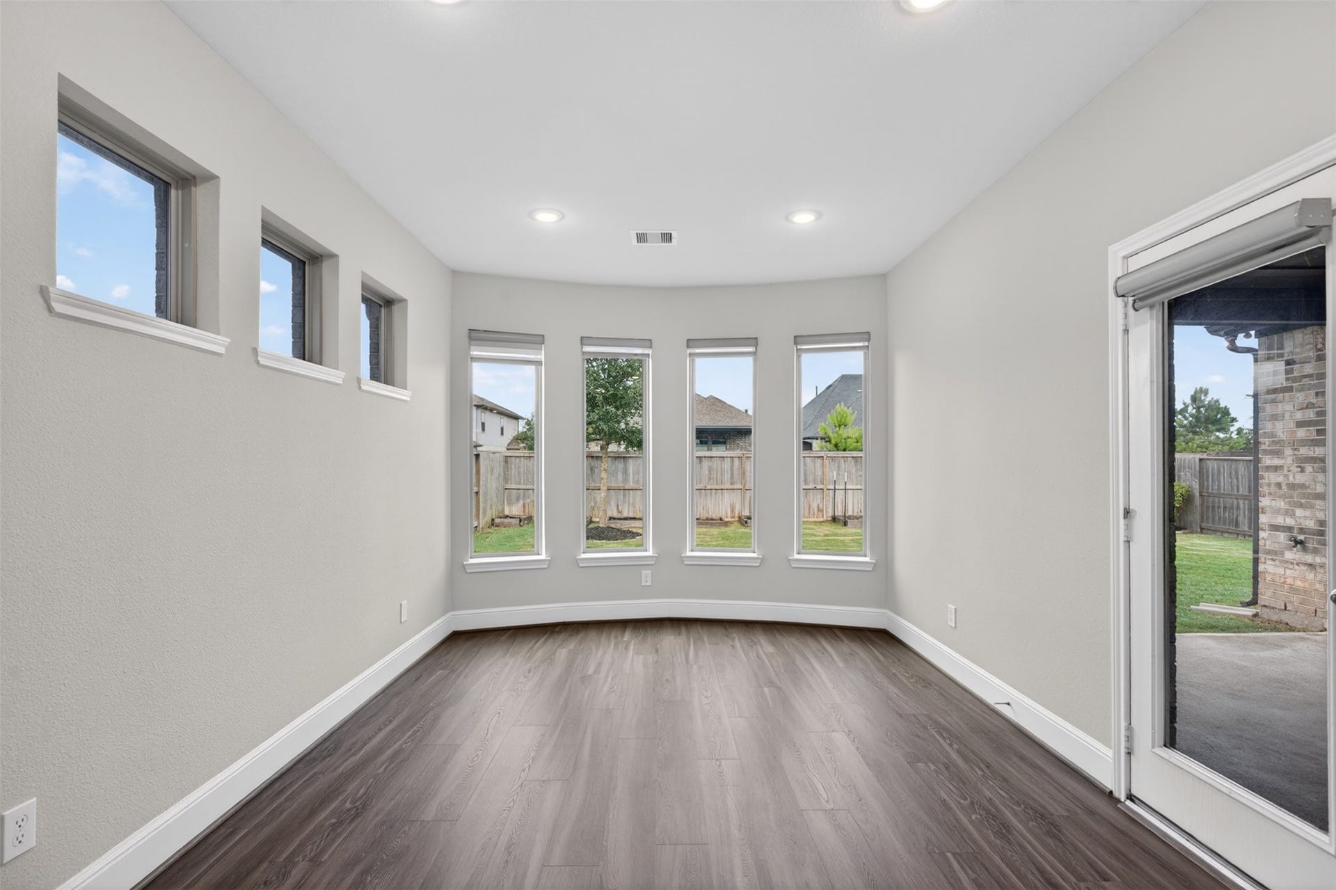 3123 Lantana Trail, Katy, TX 77493 Bathed in natural light, the dining room features a stunning wall of windows that creates a bright and inviting atmosphere throughout the day. Recessed lighting adds a warm glow in the evening, while the glass door provides convenient access to the covered patio and backyard, making indoor-outdoor entertaining effortless.