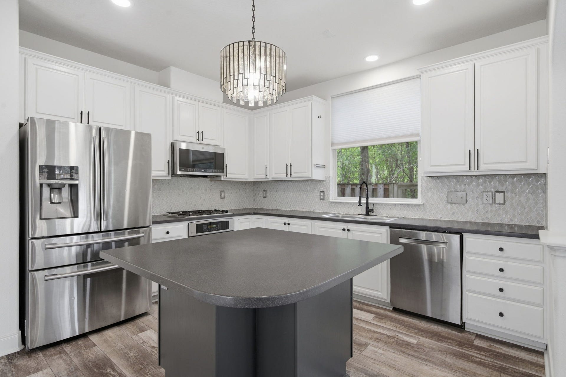 18 Cloud Bank Place, The Woodlands, TX 77382 The kitchen is equipped with SS appliances and a kitchen island.