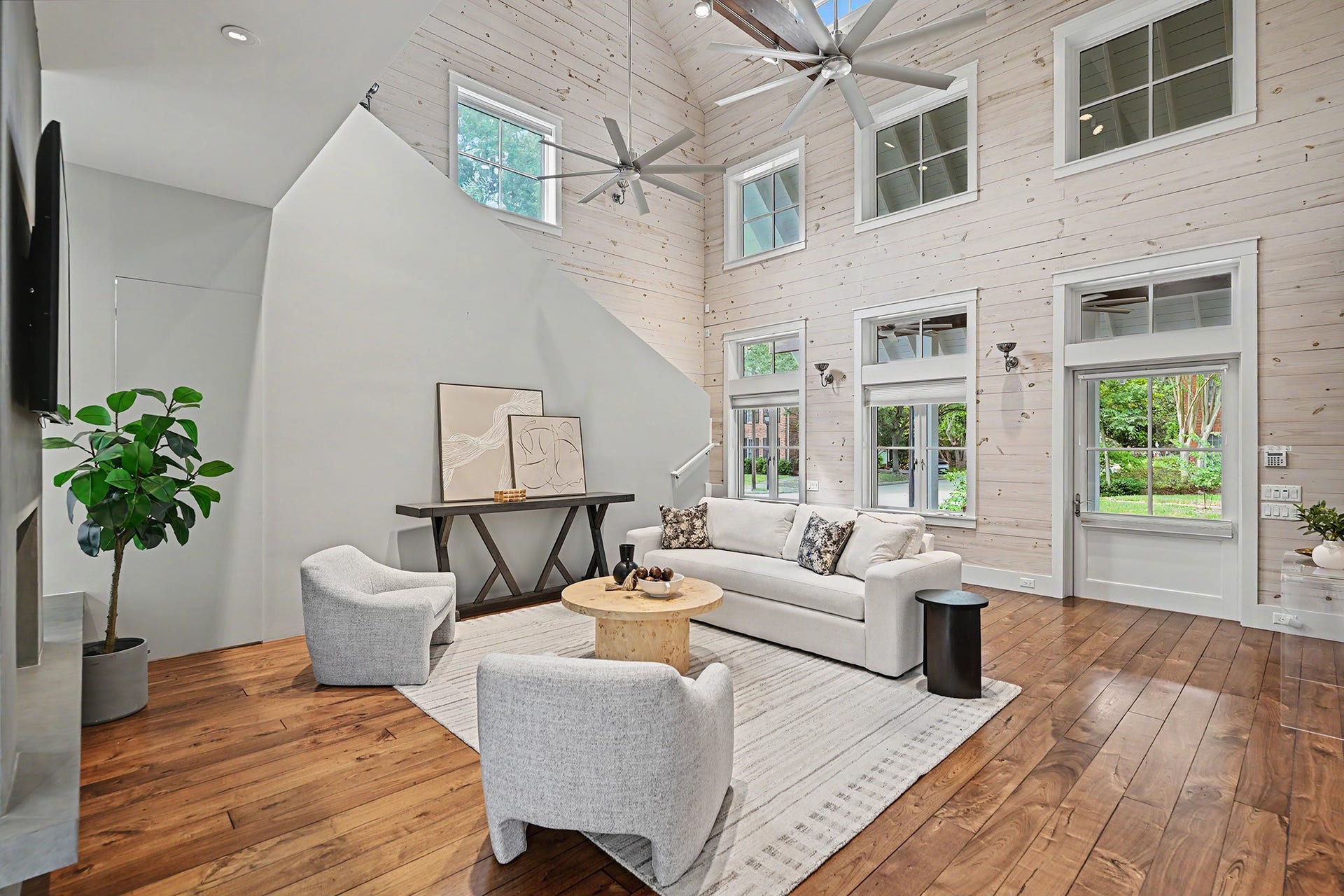 4153 Oberlin Street, West University Place, TX 77005 The expansive living room feels both grand and welcoming, with whitewashed pine shiplap walls and vaulted ceilings, beautiful walnut flooring, and abundant windows that fill the space with natural light.