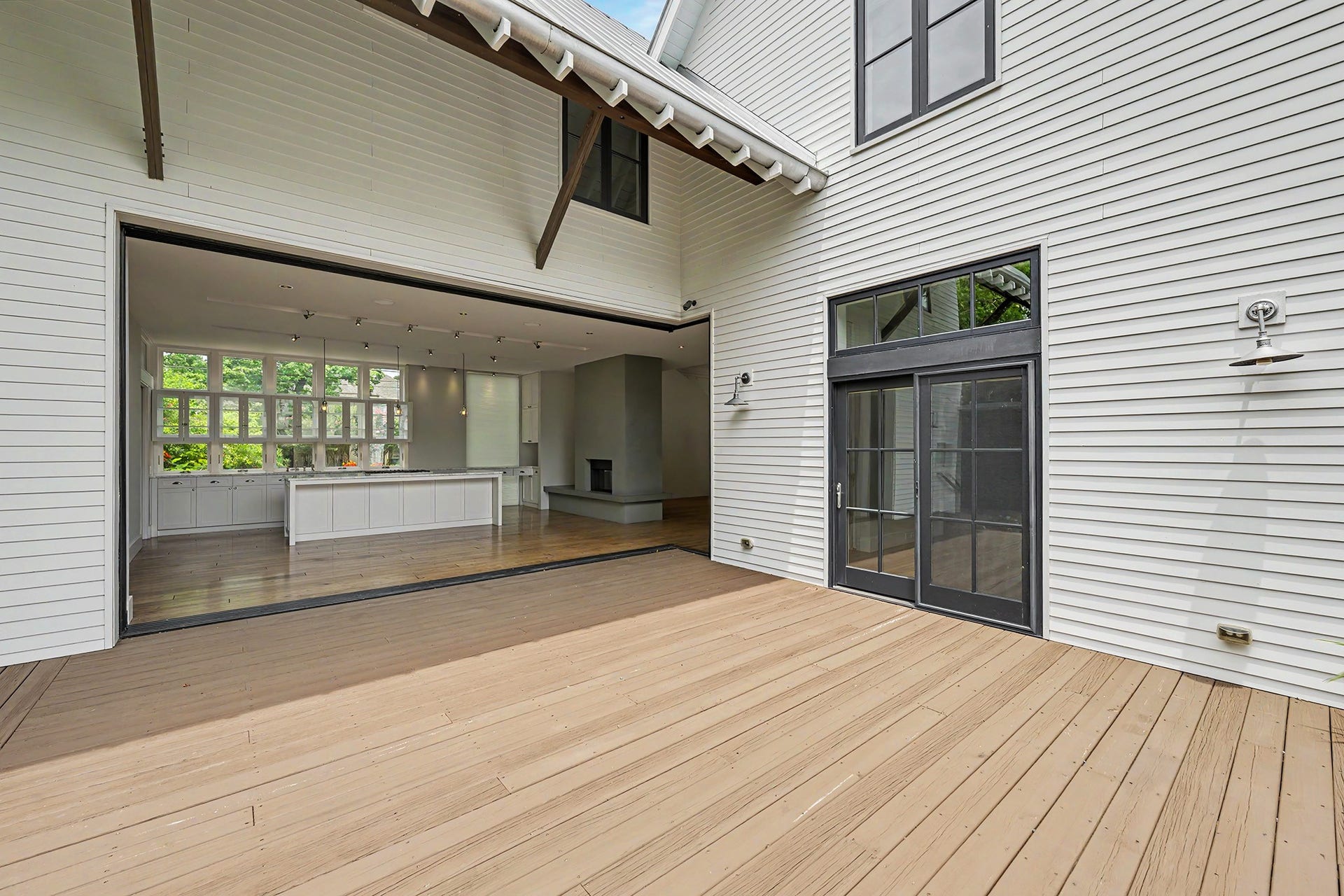 4153 Oberlin Street, West University Place, TX 77005 Looking into the dining room and kitchen from the deck emphasizes the home's indoor-outdoor connection. Double doors provide access to the primary bedroom.