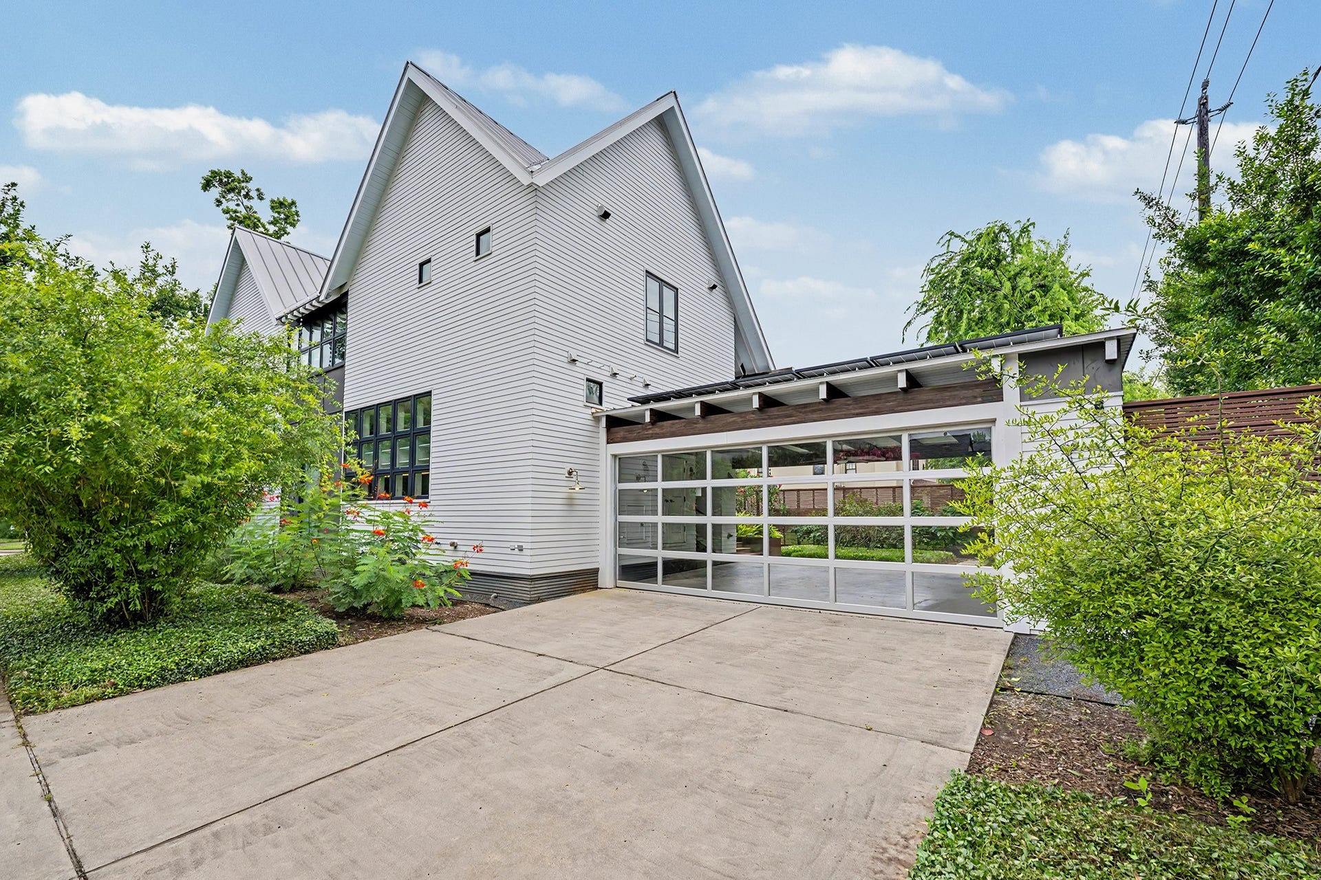 4153 Oberlin Street, West University Place, TX 77005 With a double-wide driveway and a garage featuring a modern glass door, there is plenty of convenient parking for family and guests.