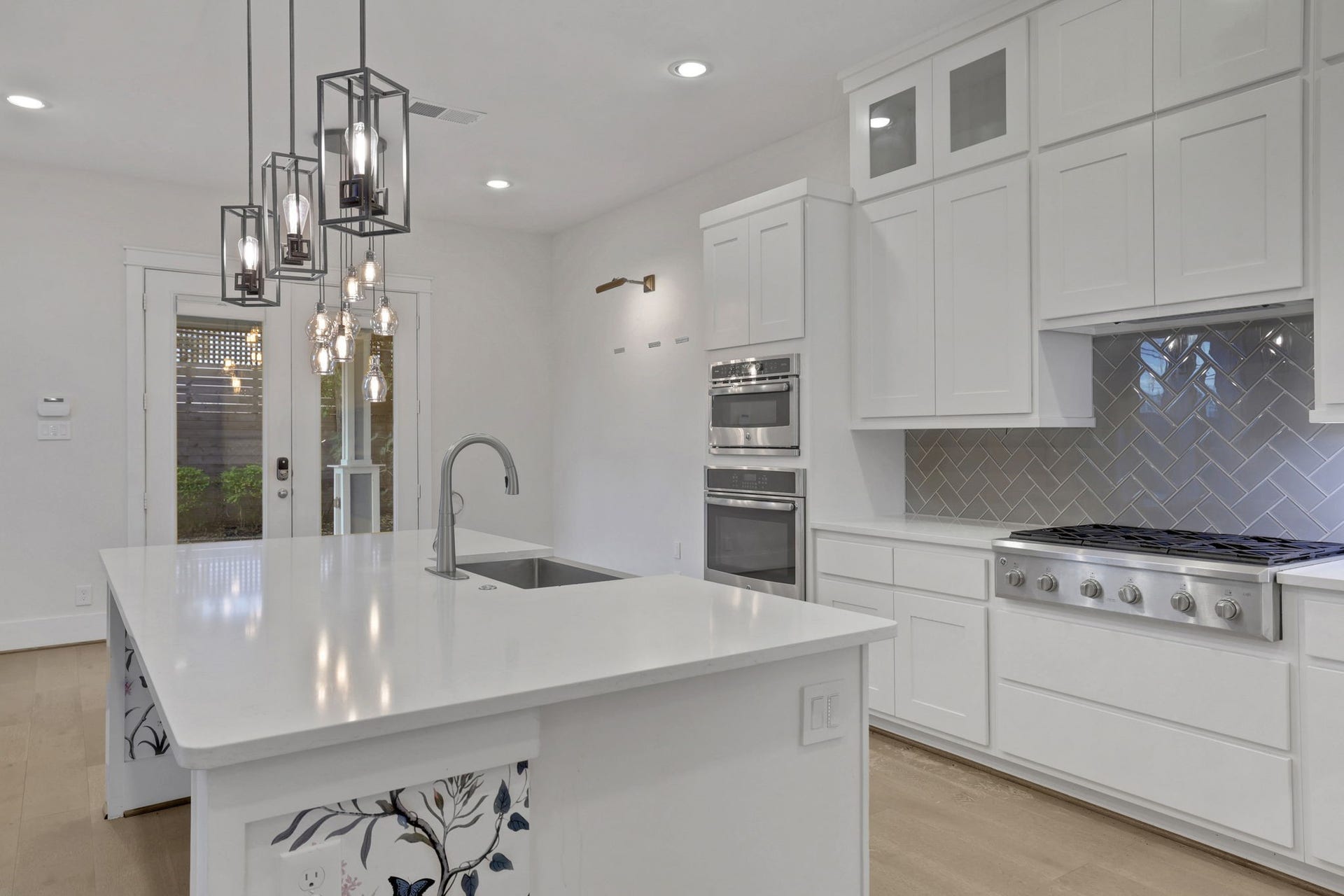 8558 Ridgepoint Drive, Houston, TX 77055 Layered cabinetry and pendant lighting define the kitchen.