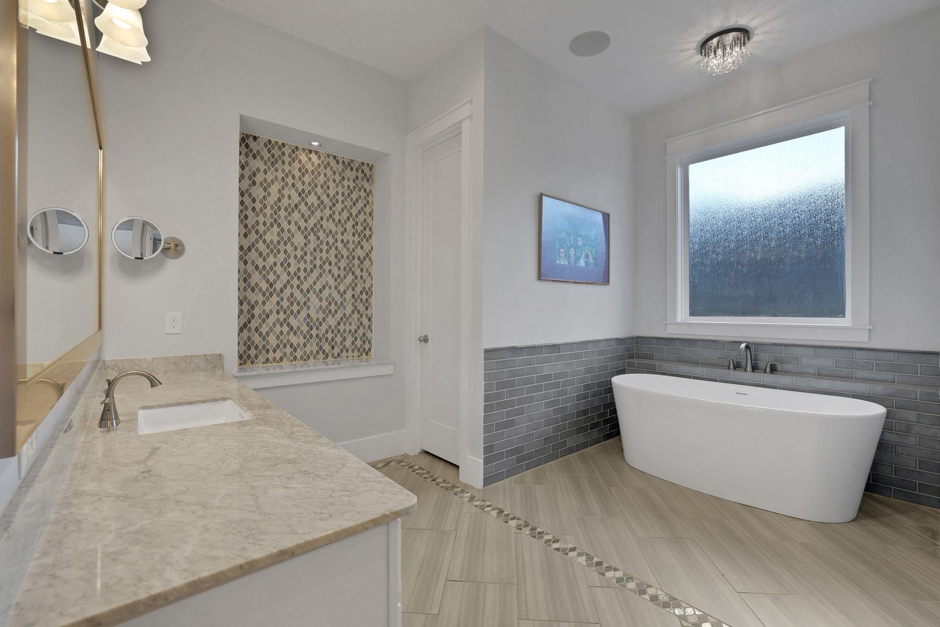 8558 Ridgepoint Drive, Houston, TX 77055 A freestanding tub sits beneath a bright window.