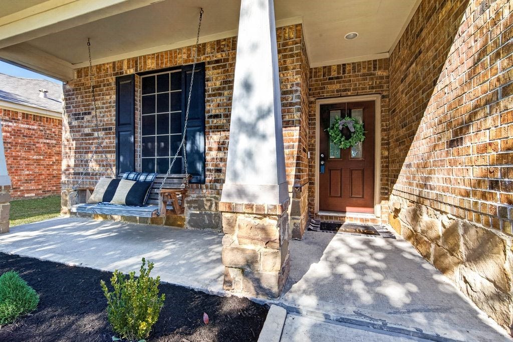 Front porch featuring gorgeous stone and covered porch with swing