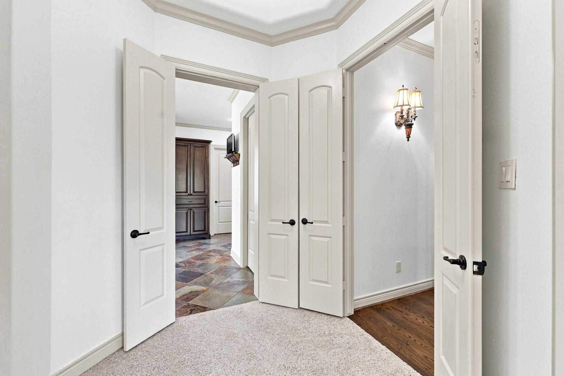 5411 Woodbury Street, Fulshear, TX 77441 This view showcases the grand entrance to the luxurious Primary Suite, creating an elegant transition from the main living areas into this private retreat. The impressive entry adds a sense of distinction and grandeur to the homes thoughtfully designed floor plan.