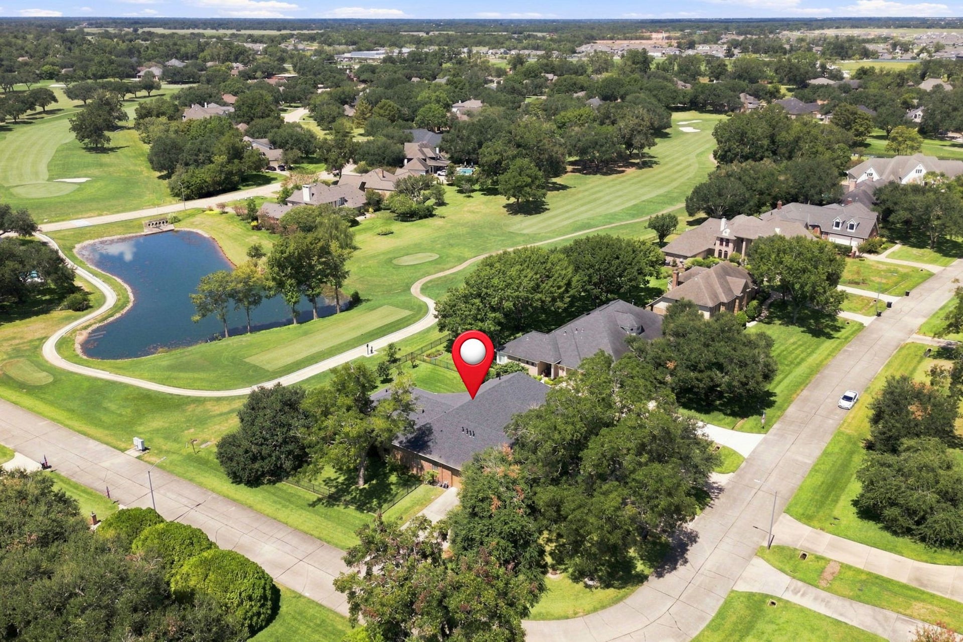 5411 Woodbury Street, Fulshear, TX 77441 This aerial view beautifully showcases the homes exceptional position on a spacious half-acre corner lot, backing to the 2nd tee box of the golf course. The expansive lot, mature trees, and picturesque golf course setting create a truly special backdrop for this remarkable property.