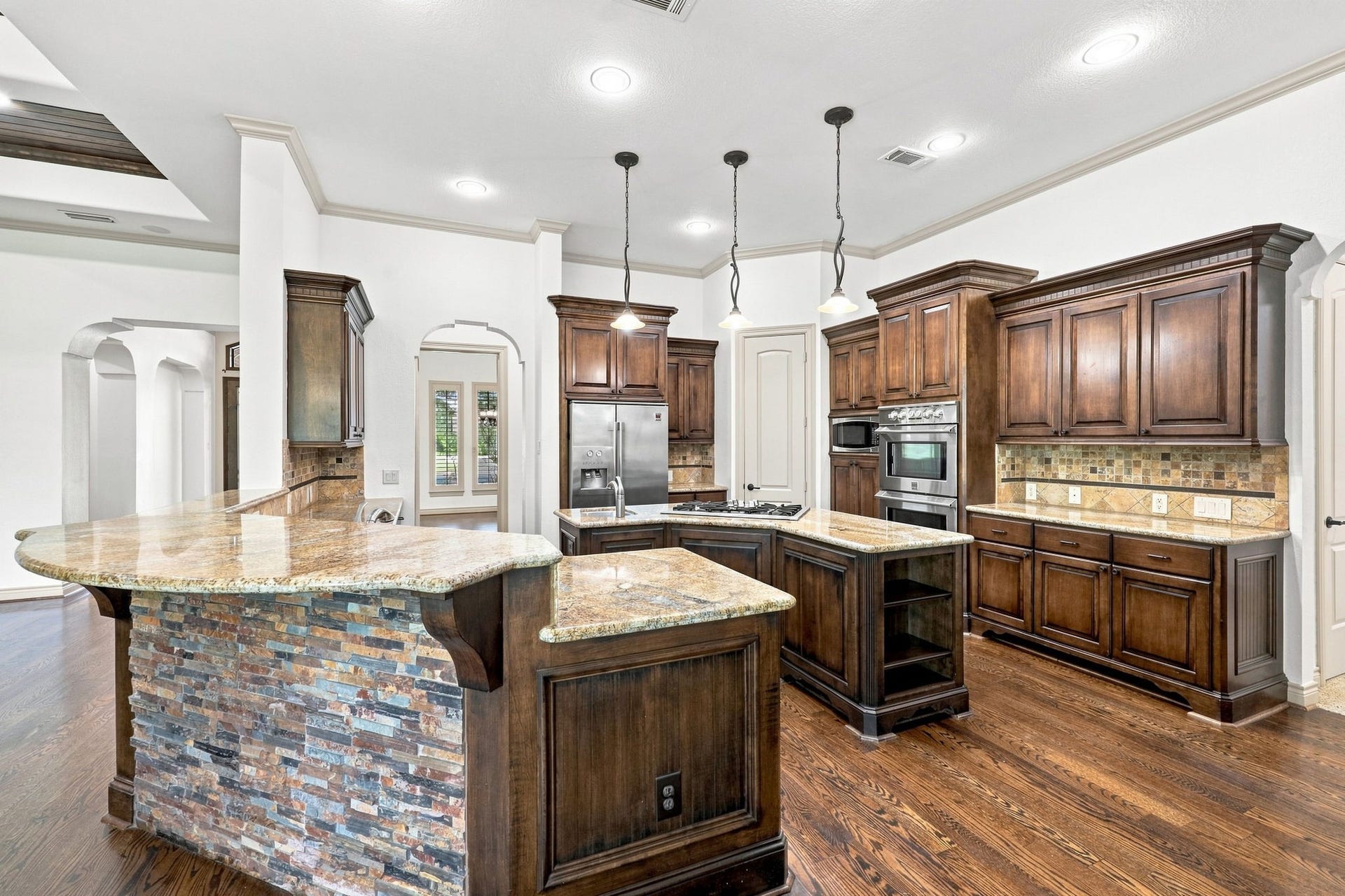 5411 Woodbury Street, Fulshear, TX 77441 The kitchen is truly a chefs dream, featuring custom cabinetry, abundant preparation space, and gorgeous granite countertops. Stainless steel appliances complement the beautifully appointed design, while the generous workspace provides plenty of room for cooking, entertaining, and gathering with family and friends.