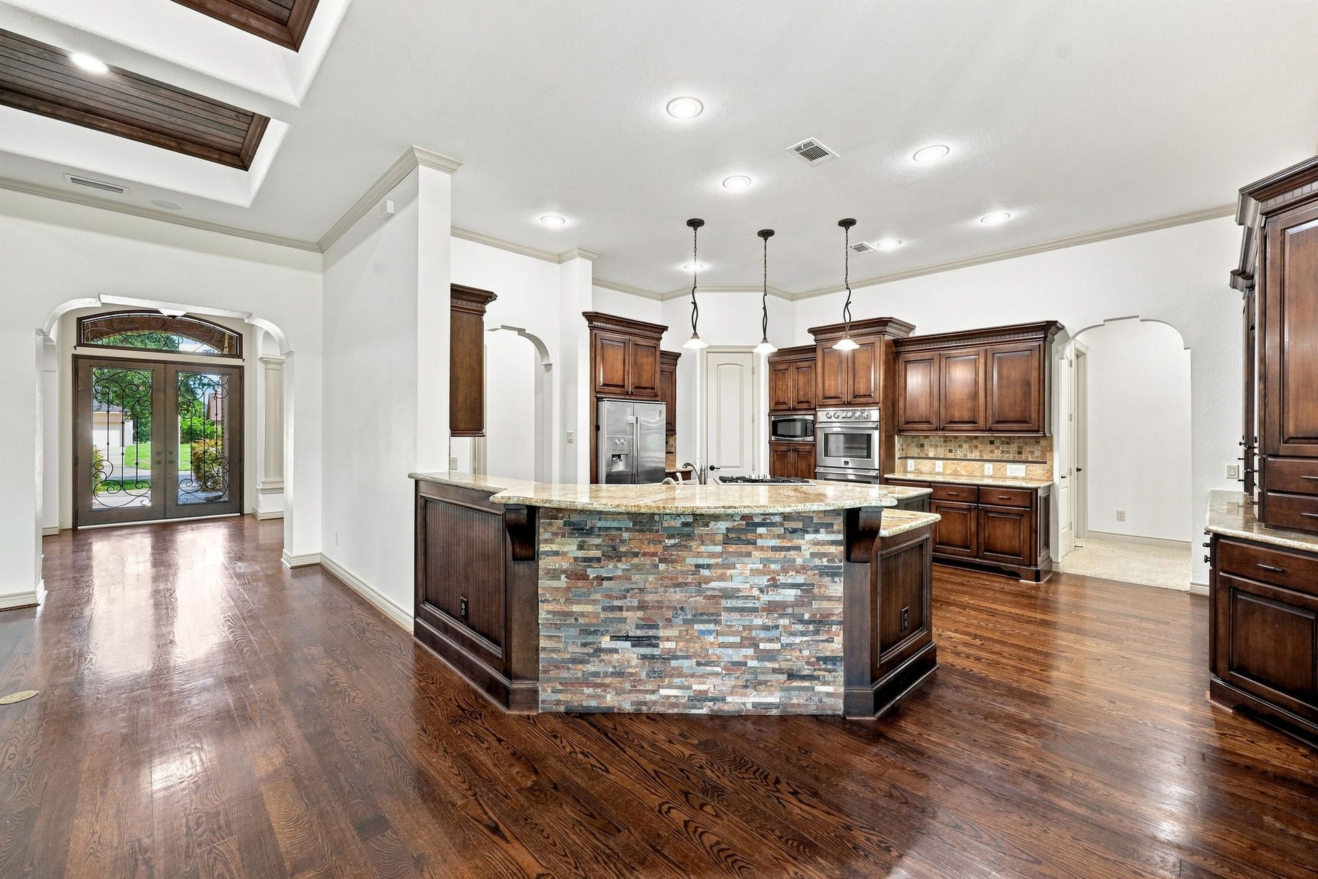 5411 Woodbury Street, Fulshear, TX 77441 This view from the Family Room looks toward the impressive front Foyer and beautifully appointed Kitchen.