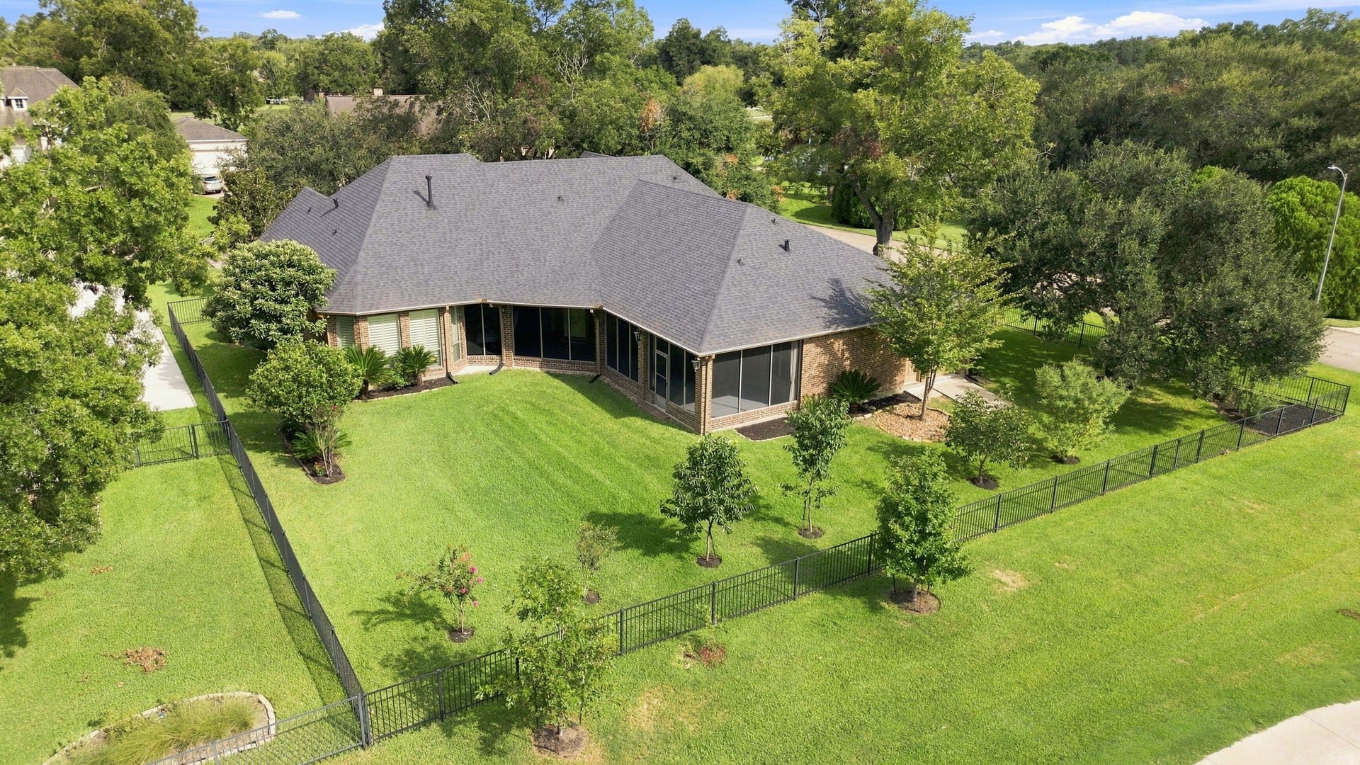 5411 Woodbury Street, Fulshear, TX 77441 A birds-eye view beautifully showcases the generous size of the backyard, along with the elegant wrought-iron fencing that defines the property. The expansive grounds offer plenty of room for a pool, outdoor entertaining, and creating your own private backyard oasis, all while enjoying the picturesque golf course setting.