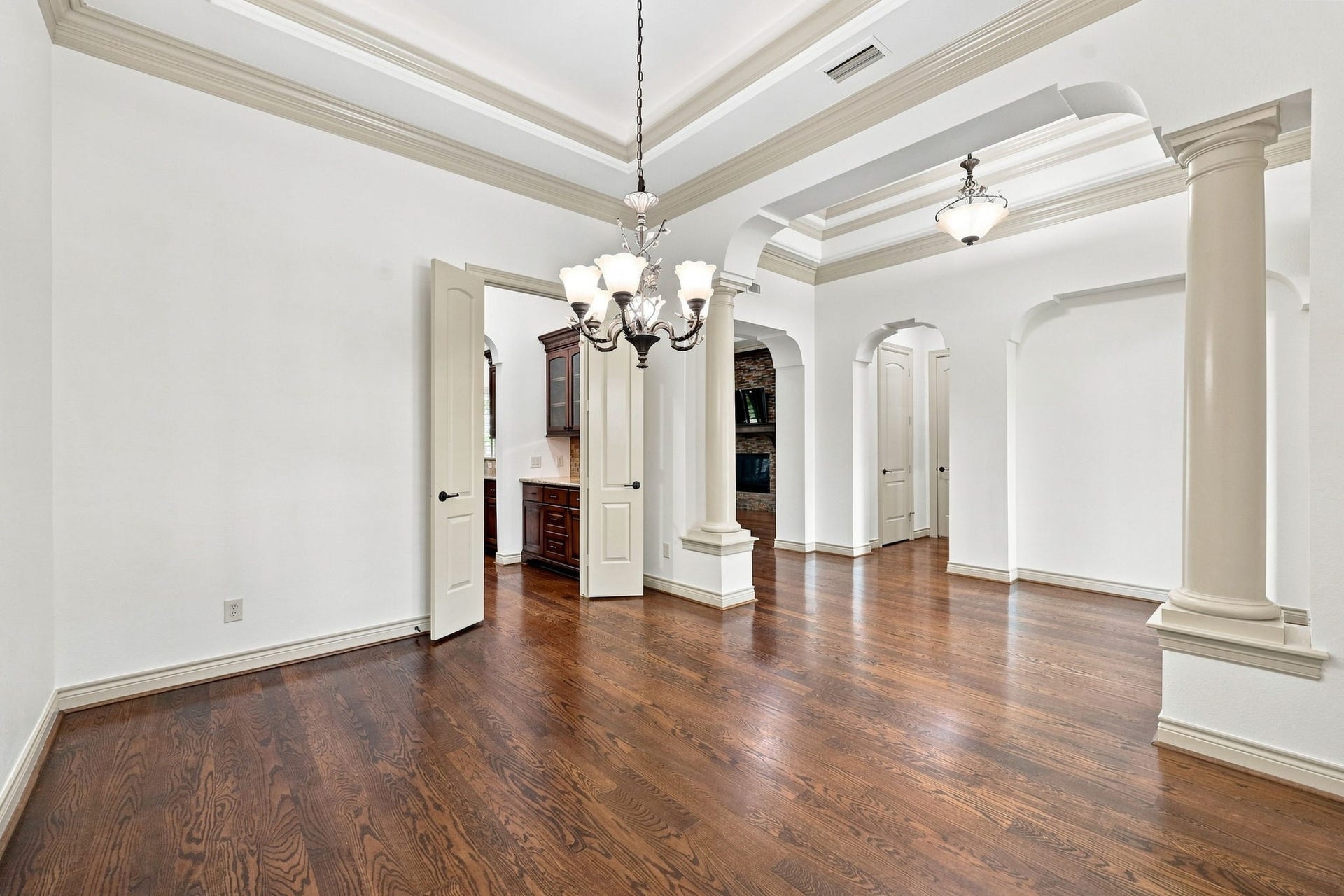 5411 Woodbury Street, Fulshear, TX 77441 This view from the opposite side of the Formal Dining room highlights the elegant double-door entry leading to the Kitchen and Butlers Pantry. The thoughtfully designed layout creates a seamless flow between the formal dining space and the heart of the home, making entertaining and serving guests effortless.