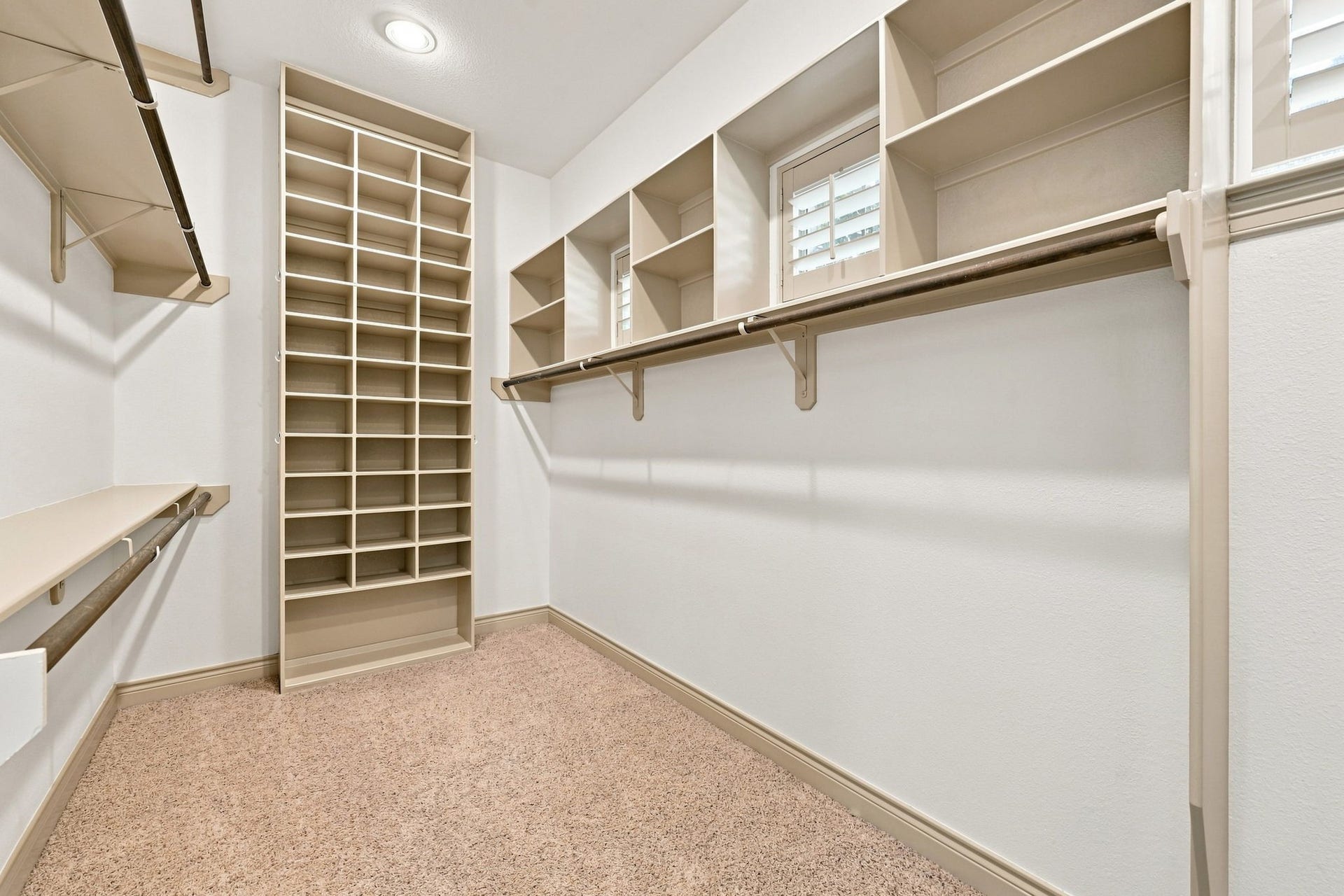 5411 Woodbury Street, Fulshear, TX 77441 The Primary Bathroom offers two separate closets, providing exceptional storage and organization. This closet features custom built-ins designed to maximize storage while keeping clothing, shoes, and personal belongings neatly organized and easily accessible.