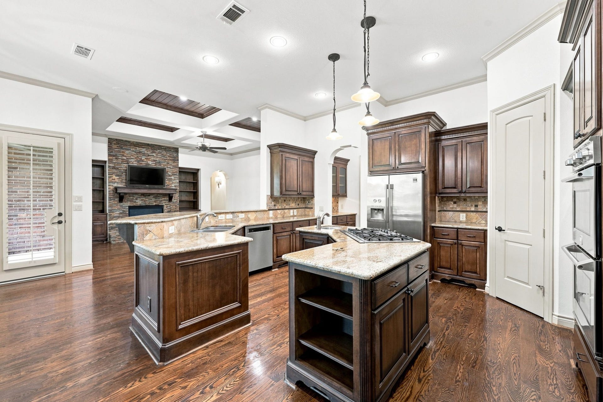5411 Woodbury Street, Fulshear, TX 77441 The spacious Kitchen Island offers abundant storage, a convenient second sink for food preparation, and generous counter space for serving, gathering, and entertaining. Three stylish pendant lights overhead add an elegant finishing touch while providing beautiful illumination to this impressive centerpiece of the Kitchen.