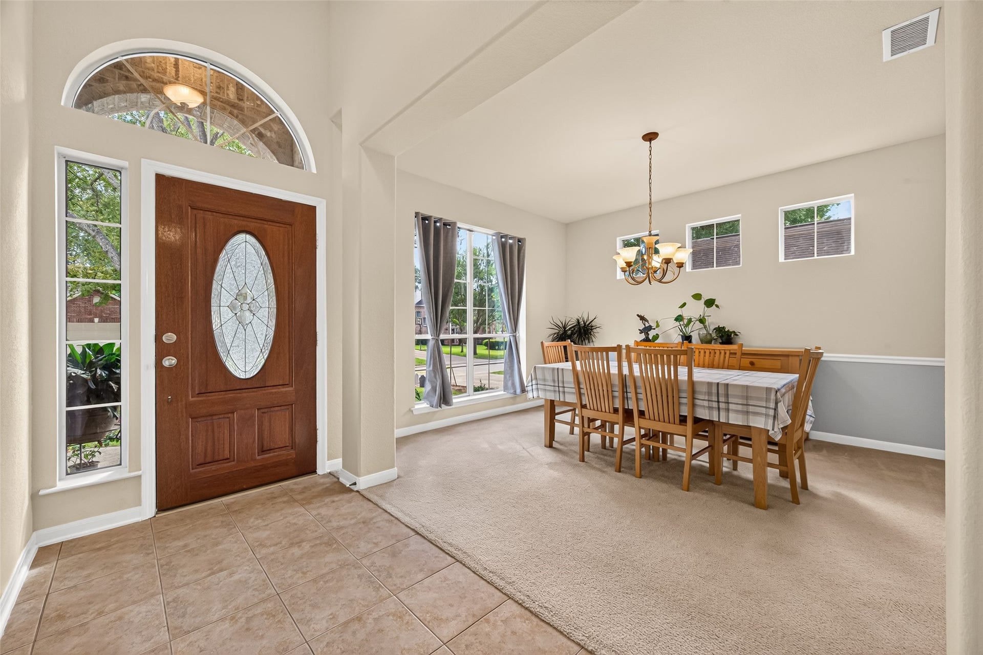 Spacious formal dining room conveniently located off the entry, featuring abundant natural light, elegant chandelier, and chair rail detailing.