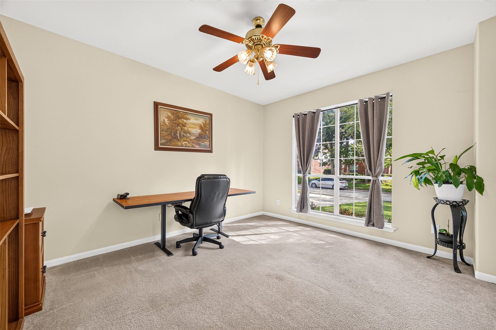 Spacious private home office featuring a large front-facing window, abundant natural light, and plenty of room for a comfortable workspace.