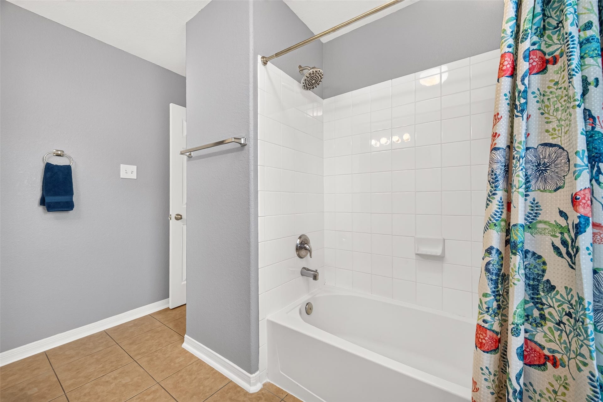 Shared Hollywood bathroom includes a tub/shower combination with classic white tile surround.