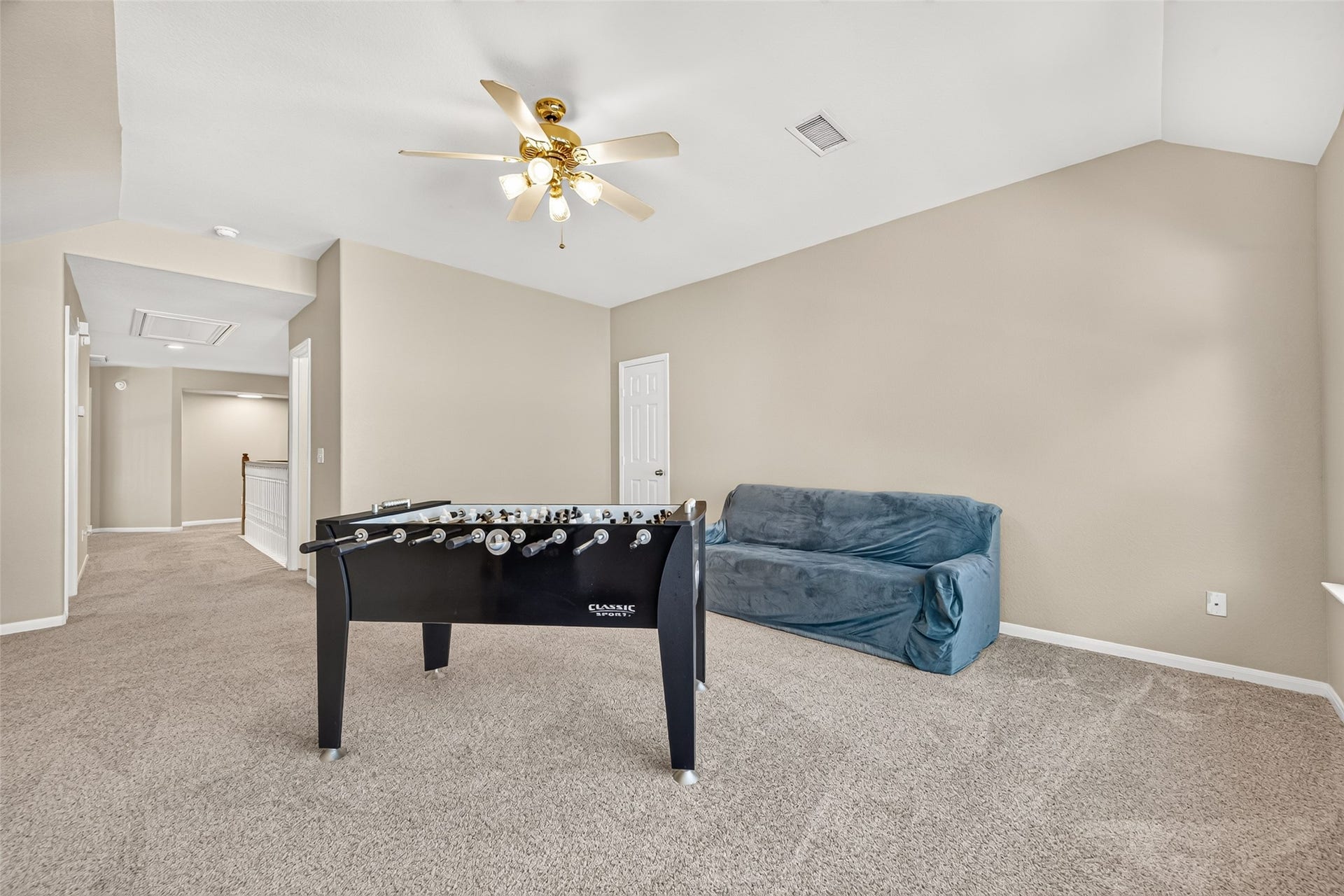 Additional view of the spacious game room highlighting the open layout and convenient access to the upstairs bedrooms.