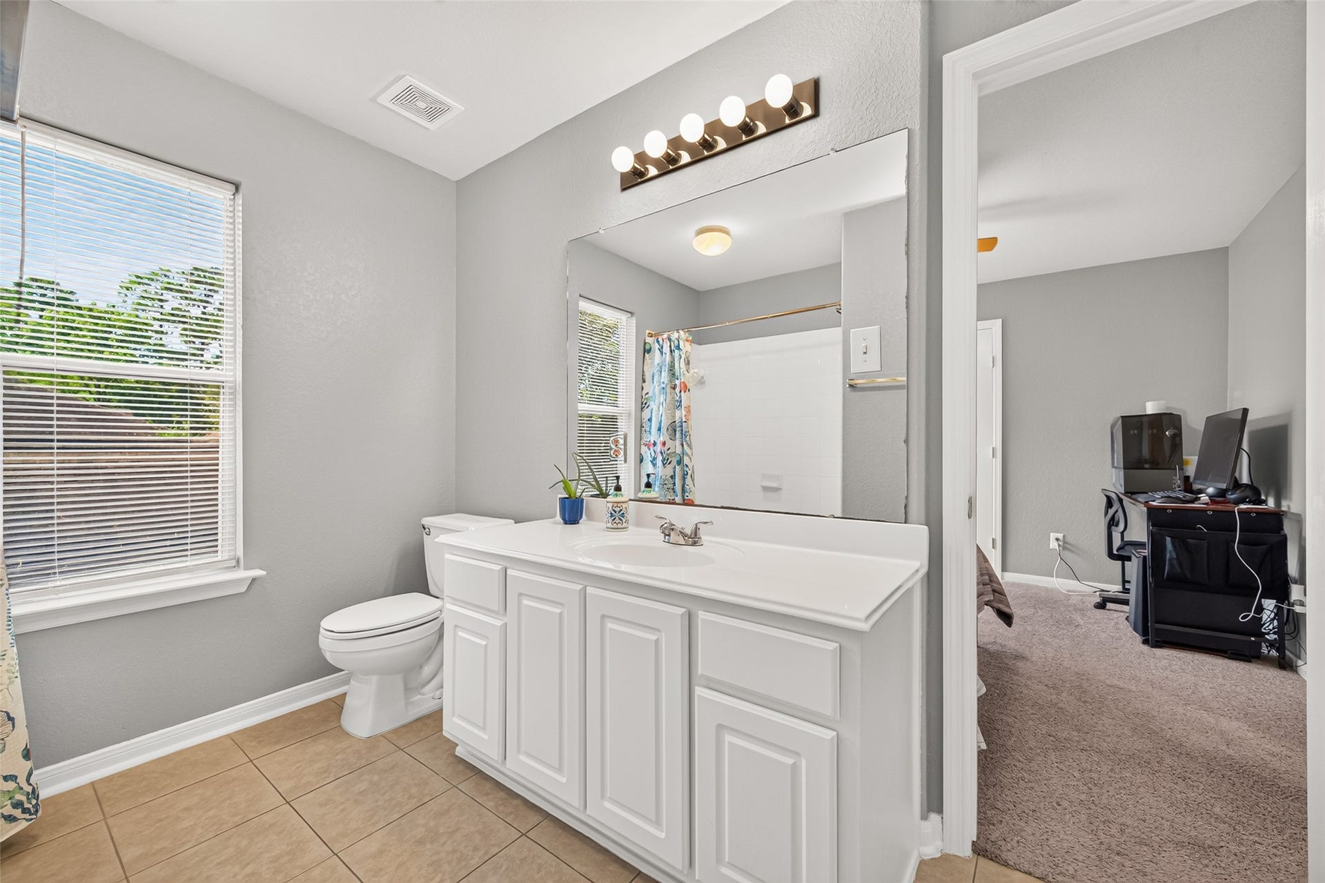 Convenient Hollywood-style bathroom connecting two upstairs bedrooms, featuring a spacious vanity and natural light.
