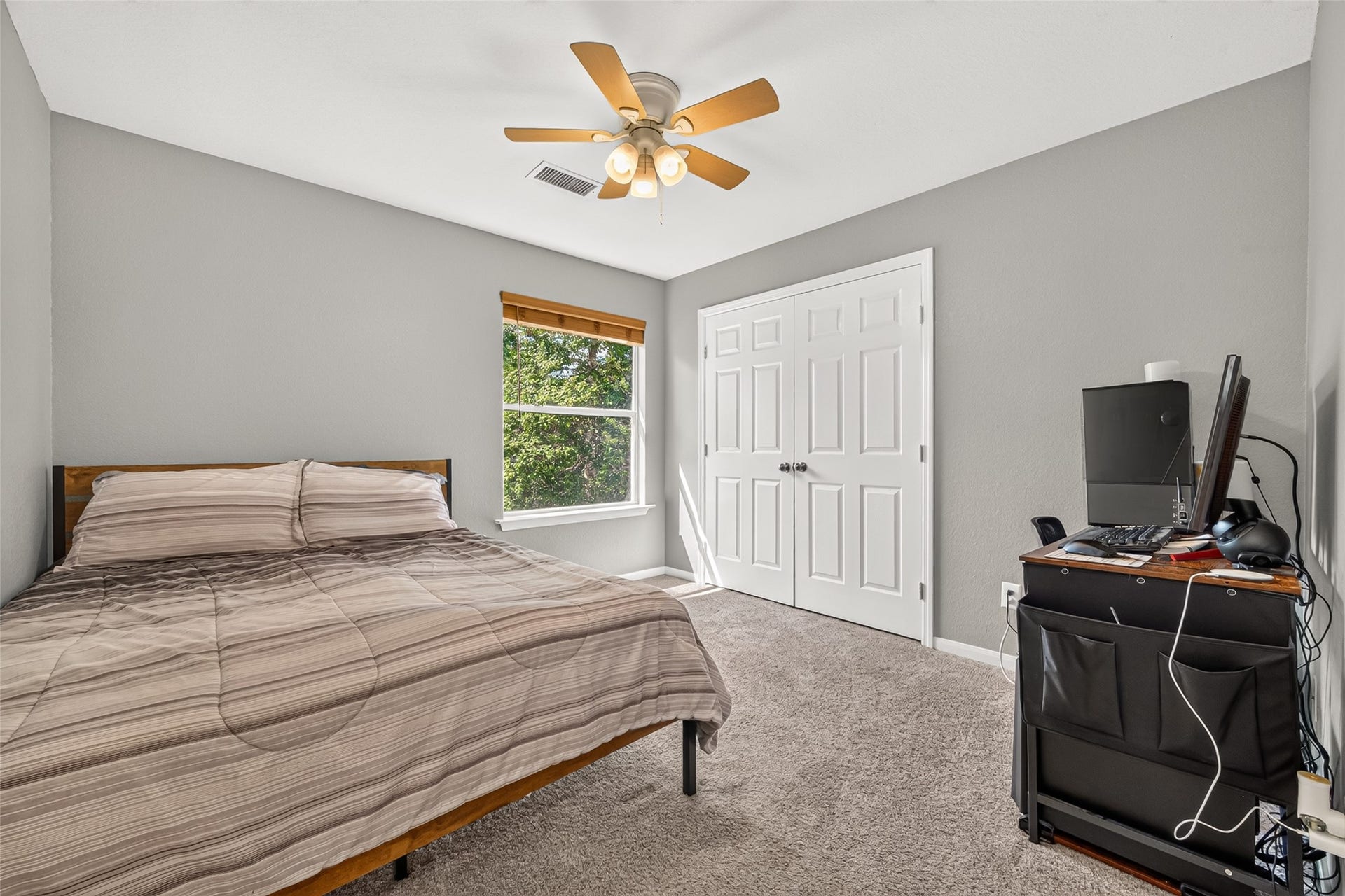 Upstairs secondary bedroom featuring natural light, a ceiling fan, and a spacious closet.