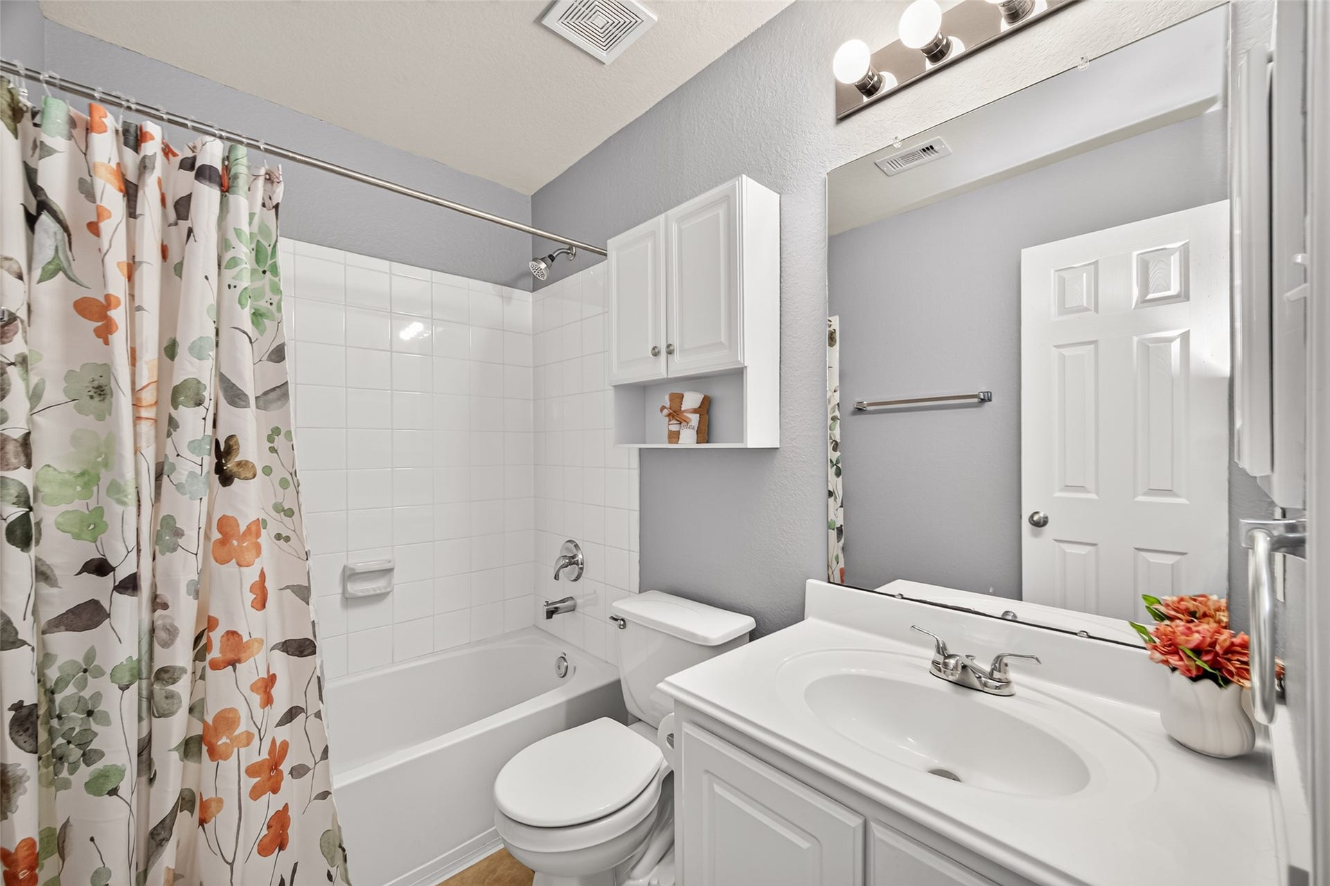 Additional upstairs full bathroom featuring a tub/shower combination, white vanity, and convenient access from the hallway.