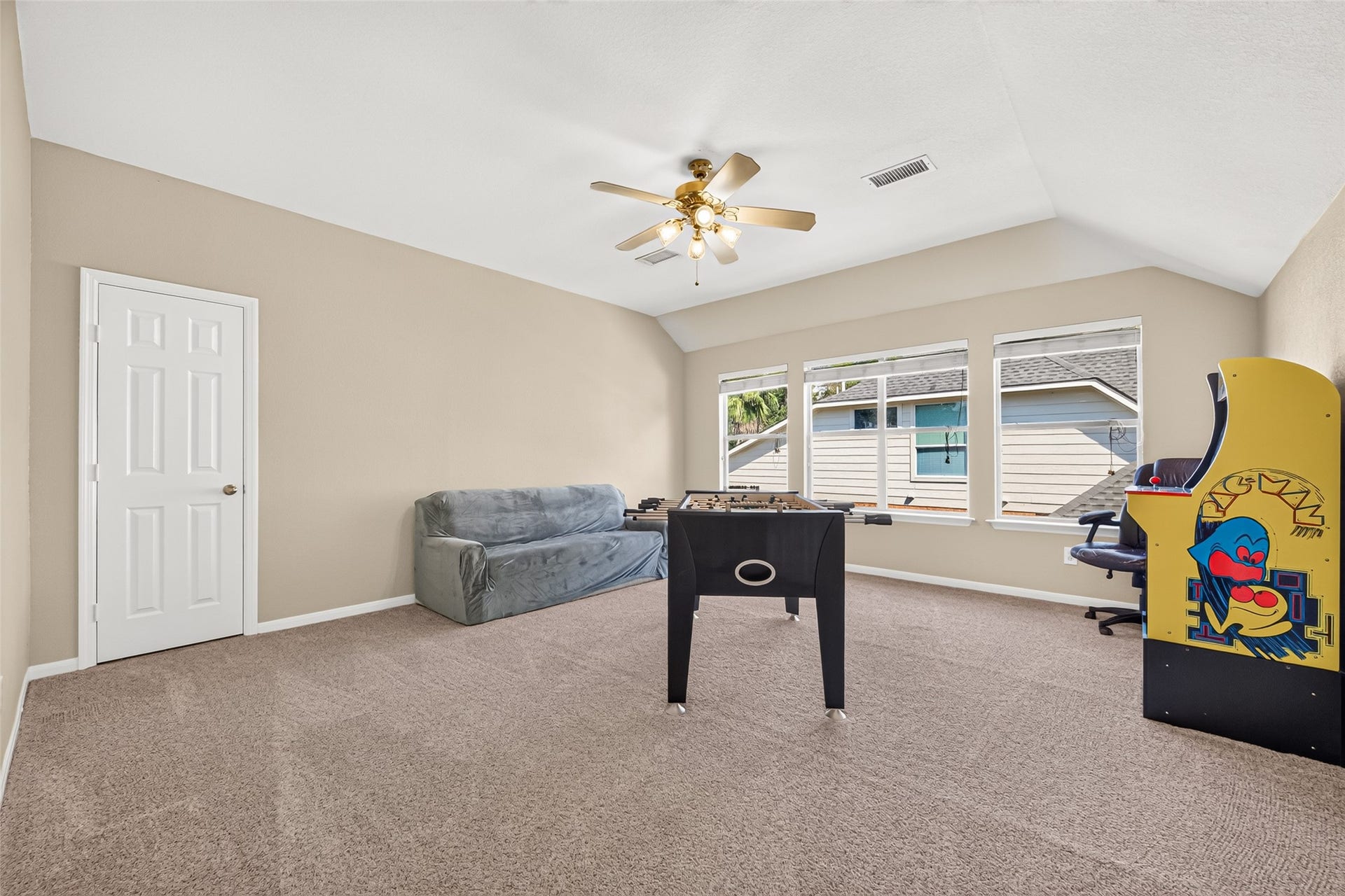 Oversized upstairs game room featuring vaulted ceilings, abundant natural light, and plenty of space for entertainment, games, and relaxation.