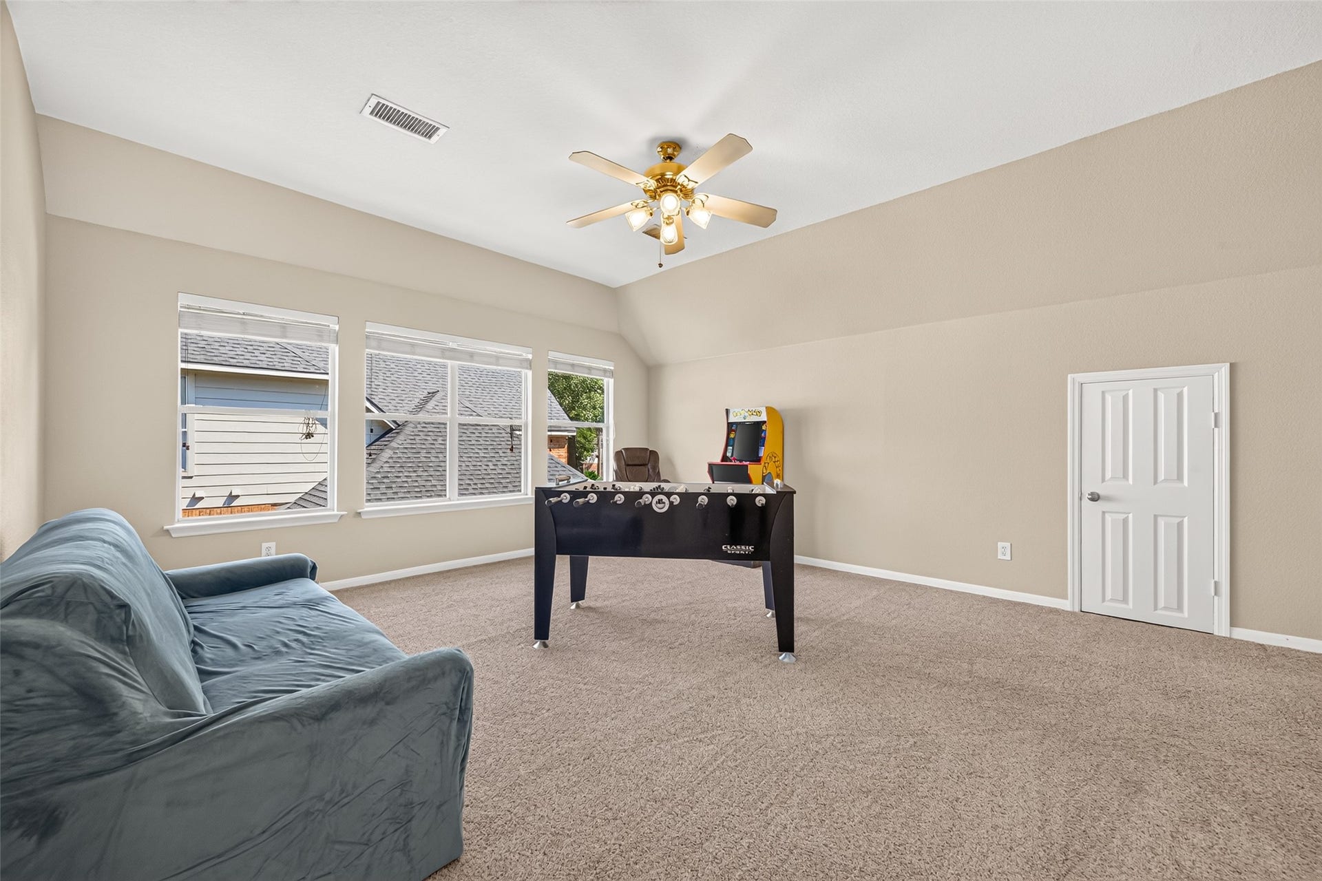 Versatile upstairs retreat offering ample space for a media area, game tables, or additional gathering space.