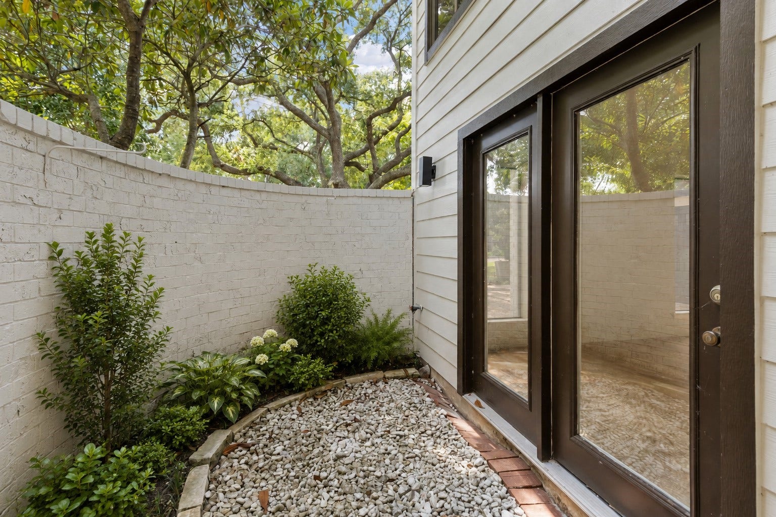 190 Dawns Edge Drive, Montgomery, TX 77356 A private courtyard just off the primary bedroom allows natural light through a glass door while maintaining privacy. (Some of the plants have been virtually staged)