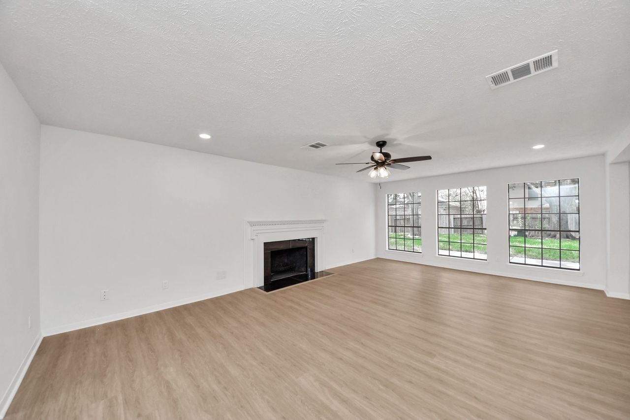 15047 Tramore Drive, Houston, TX 77083 The classic fireplace anchors the room, while the surrounding windows fill the space with natural light and offers views toward the beautifully landscaped yard.